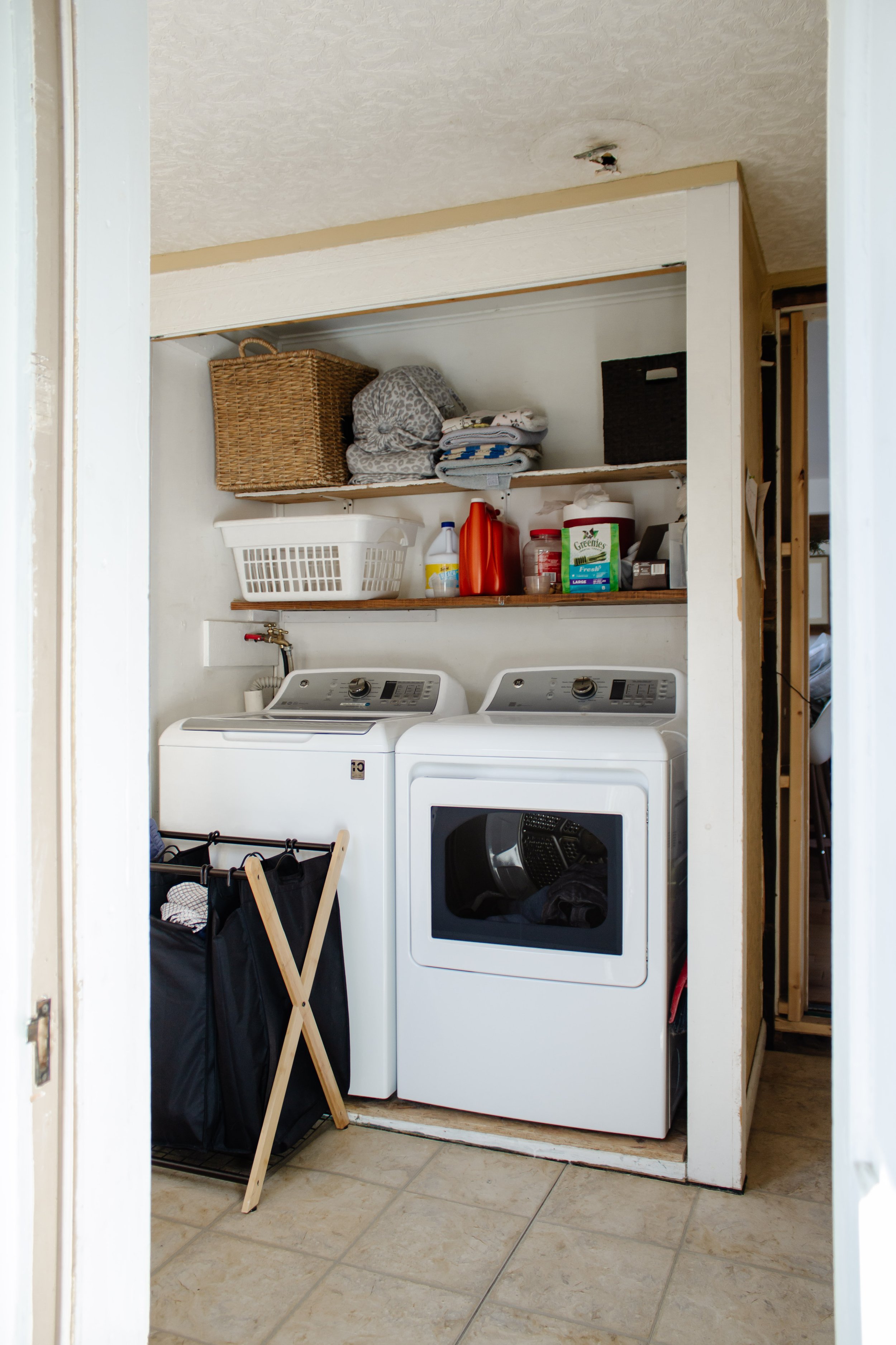 Laundry closet makeover by Nadine Stay | How to maximize storage space in a laundry closet. Stackable washer and dryer I love. Linen closet inspiration. Pull out hamper in closet. Rustic laundry room. Brown doors.