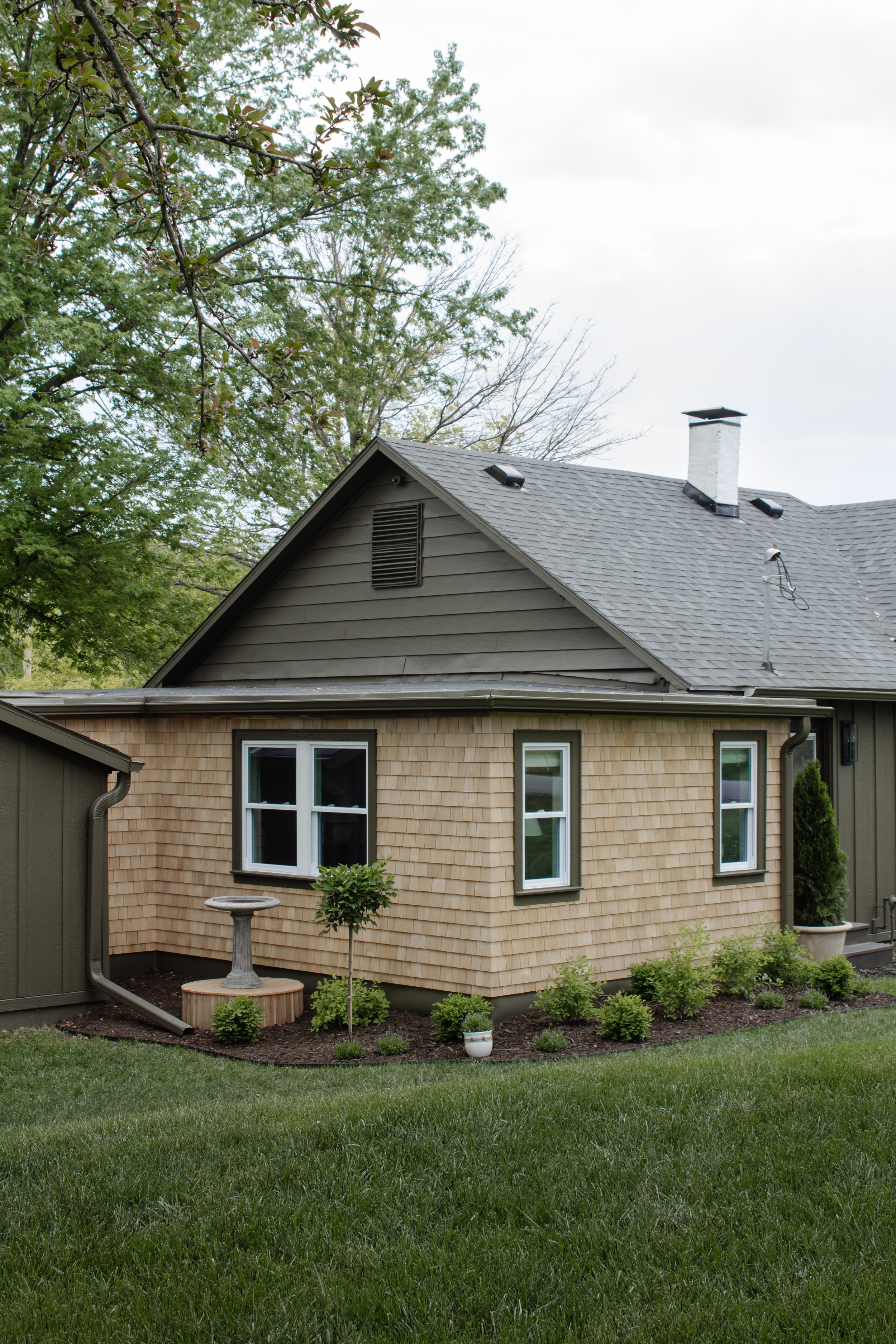Cedar shingle exterior siding reveal. How we remodeled our exterior from rusty siding to cedar shakes. Hunter green and cedar shingle exterior transformation. English garden landscaping inspiration. | Nadine Stay