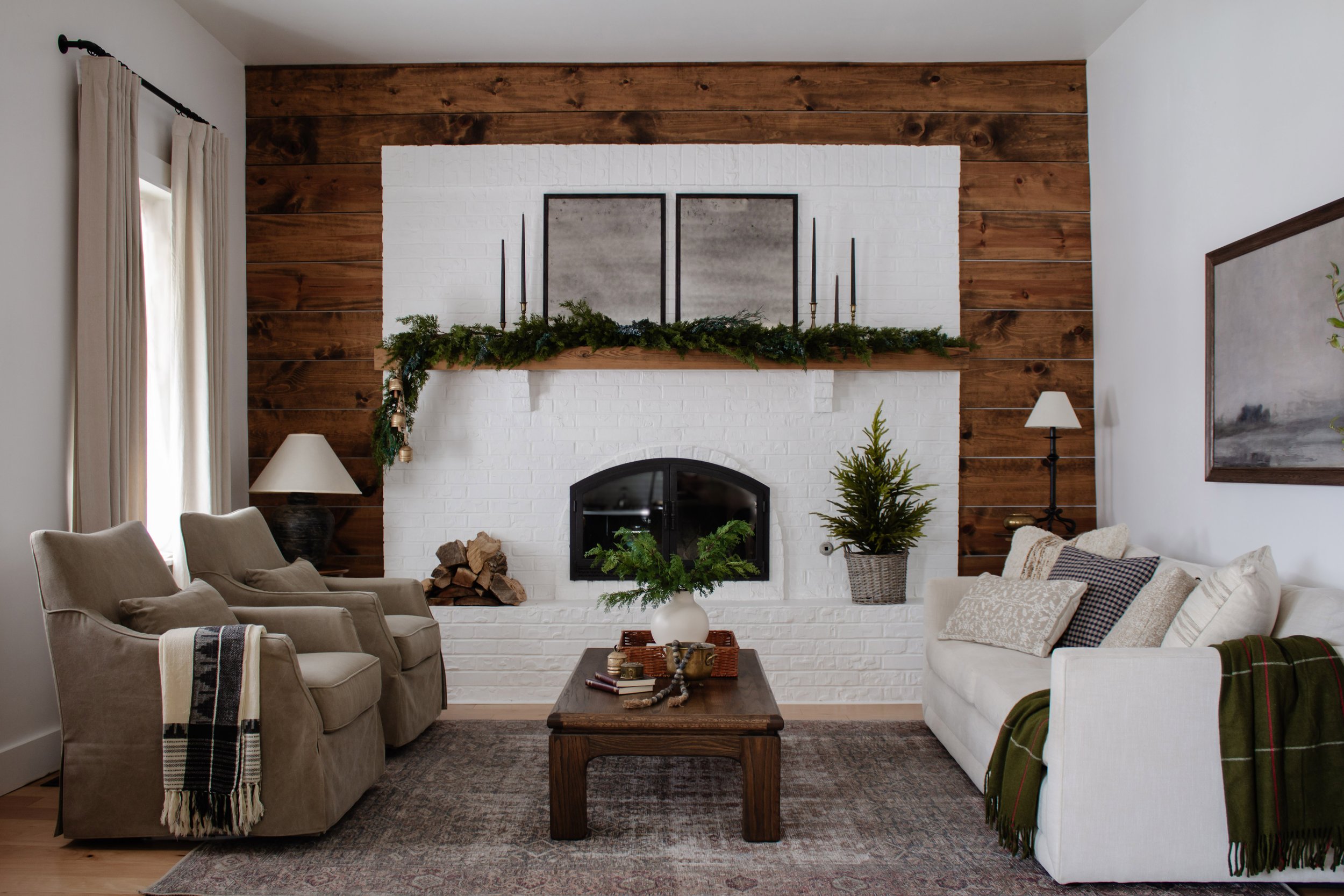Cozy Christmas living room decor. Holiday mantle decor. Faux garland that looks real. Faux pine branches for Christmas decor. Fireplace decorating ideas for Christmas. Simple Christmas decor by Nadine Stay