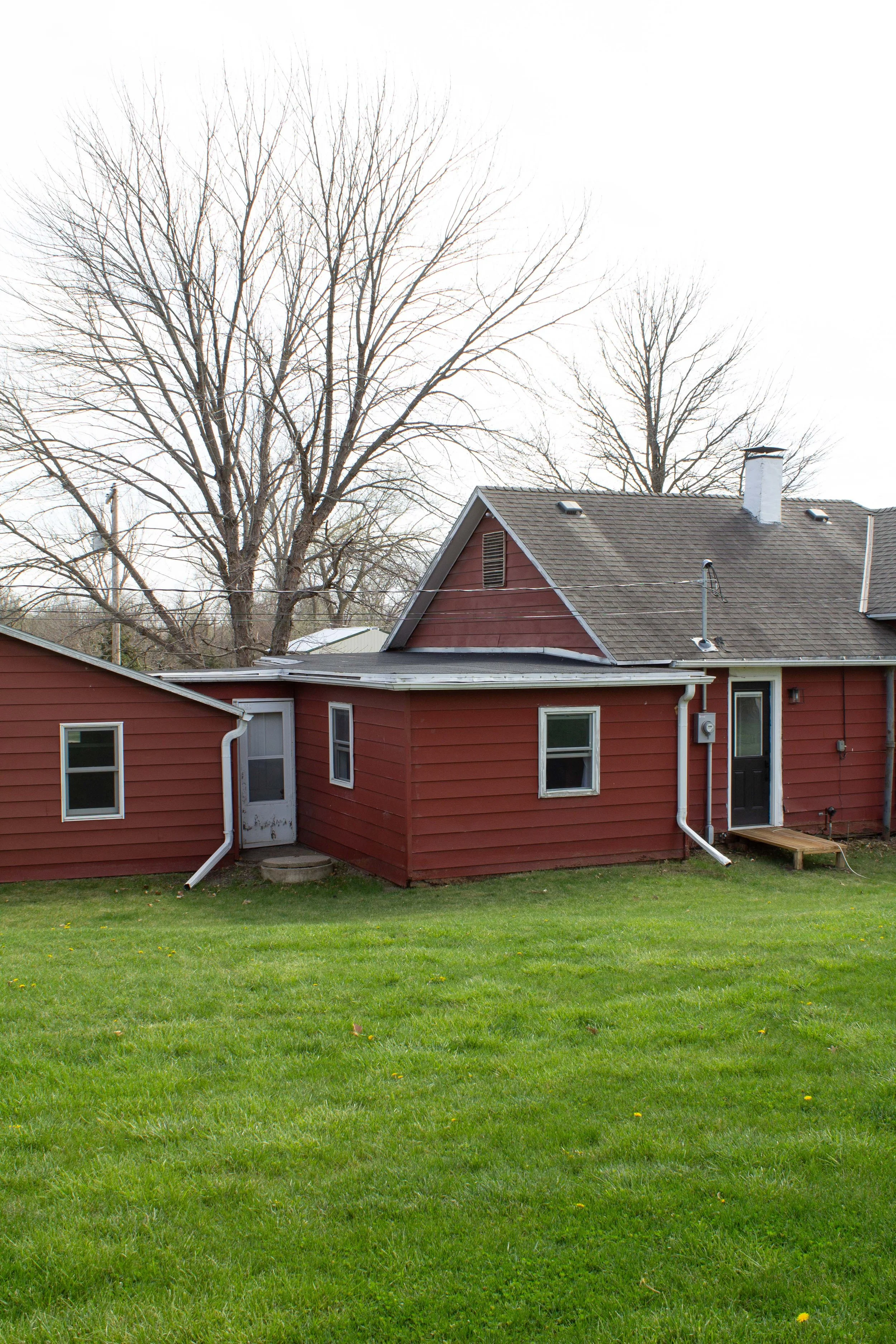 BEFORE | Cedar shingle exterior siding reveal. How we remodeled our exterior from rusty siding to cedar shakes. Hunter green and cedar shingle exterior transformation and inspiration. | Nadine Stay