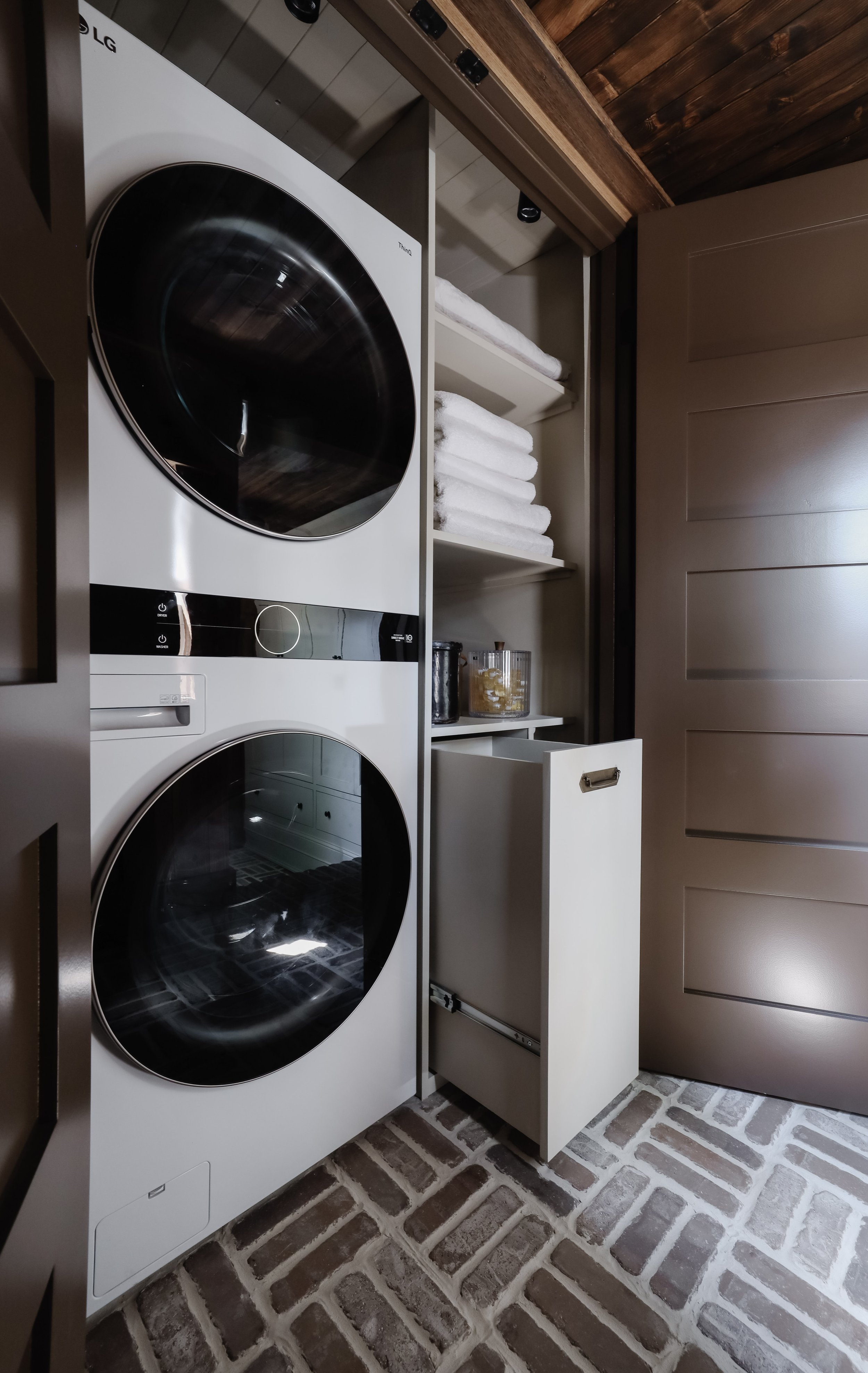 Laundry closet makeover by Nadine Stay | How to maximize storage space in a laundry closet. Stackable washer and dryer I love. Linen closet inspiration. Pull out hamper in closet. Rustic laundry room. Brown doors.