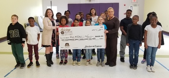 Stacy Adams, Ghertner & Company Director of Human Resources presents the check to these deserving young people and leaders.