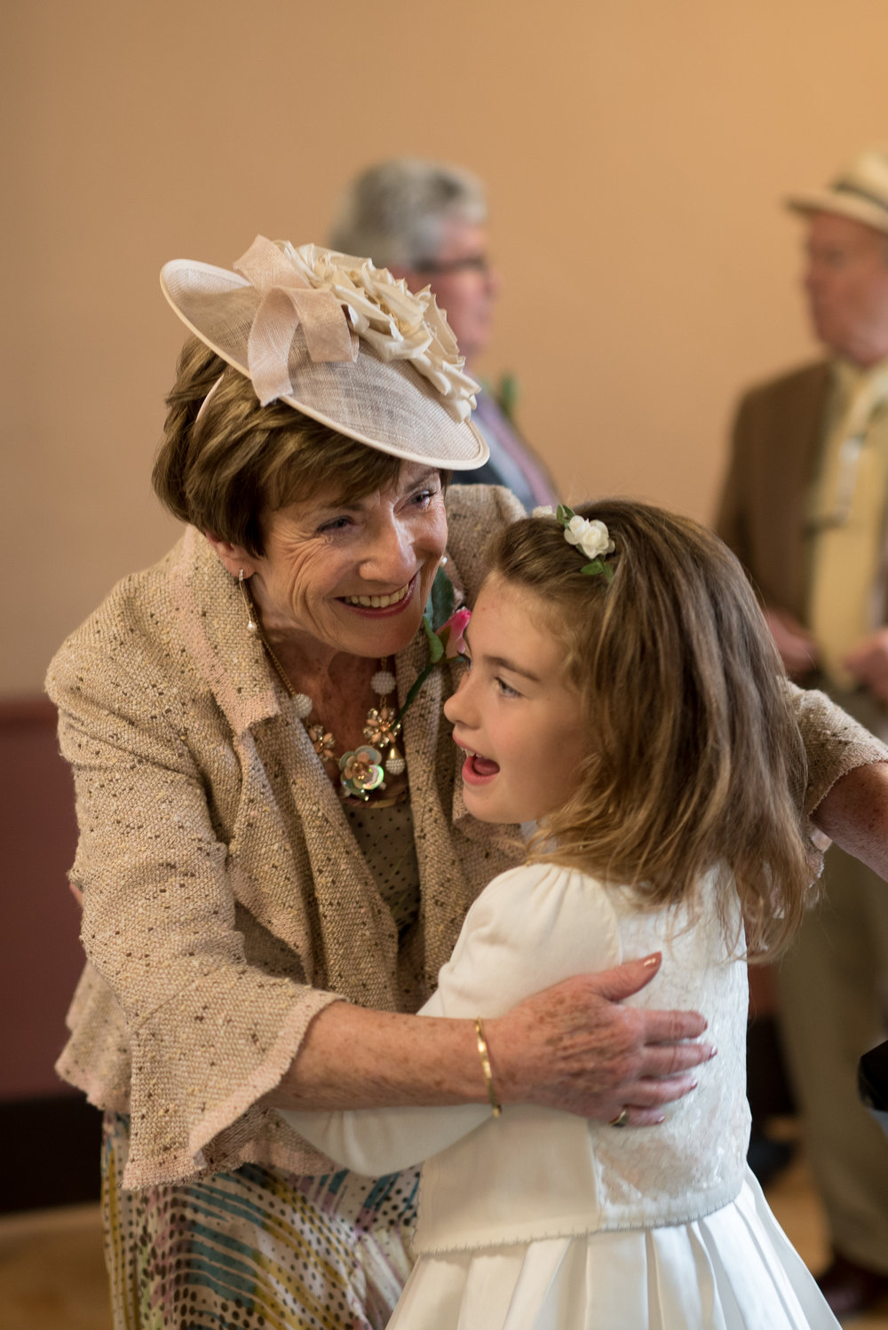 Grandmother embraces granddaughter flower girl at wedding