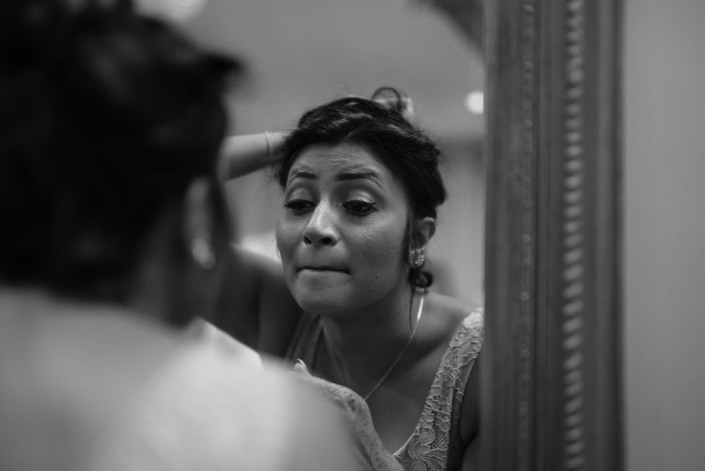 Bridesmaid applying lipstick at Tythe Barm wedding ceremony