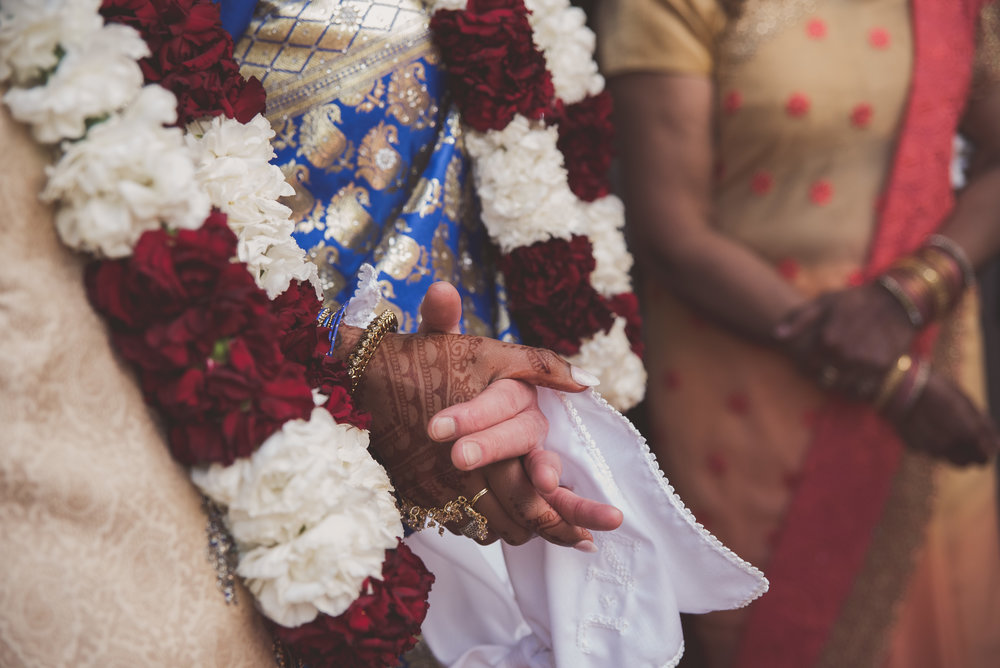 Bride and groom hold hands at Hindu wedding ceremony