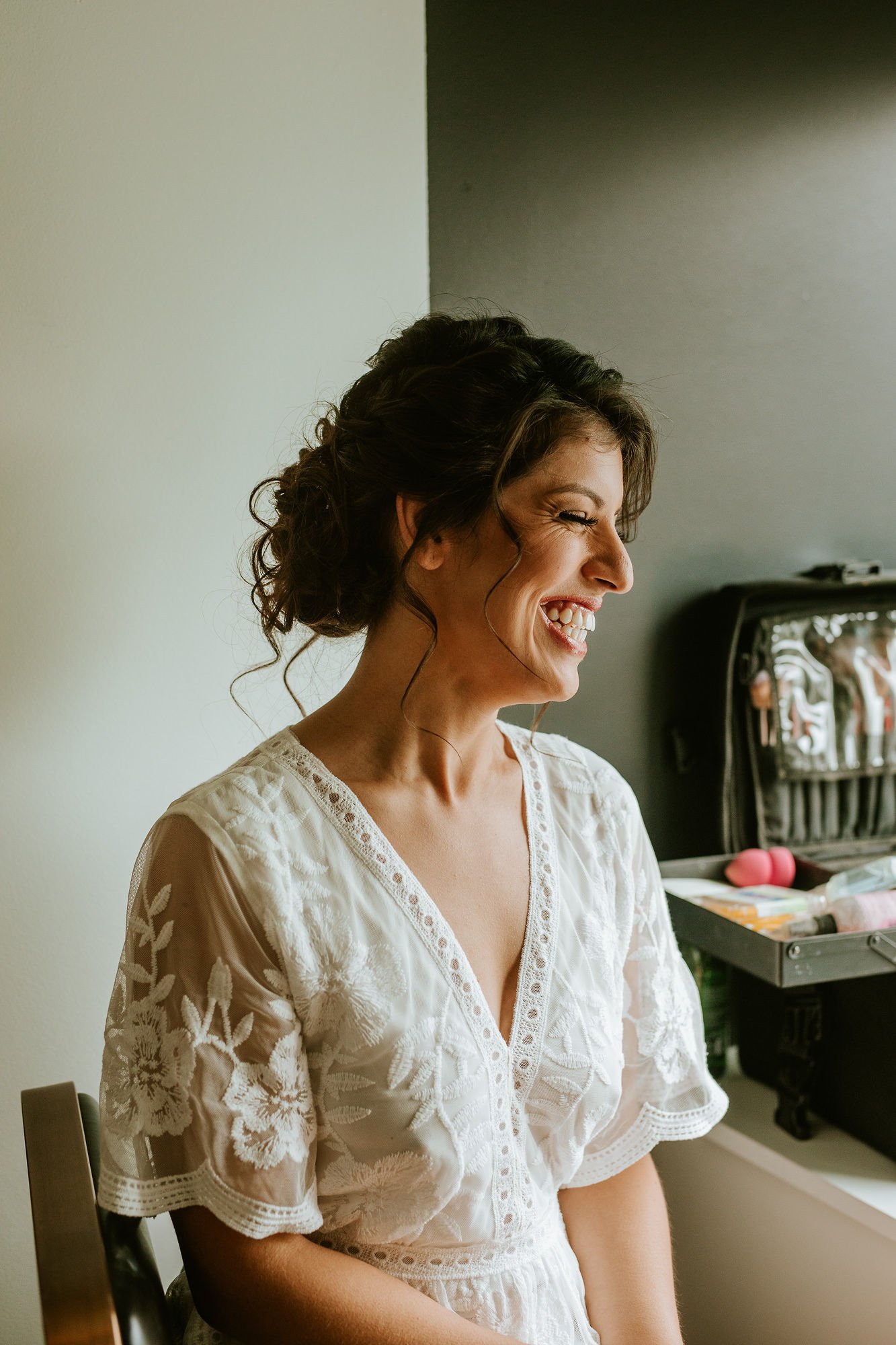 Bride laughing while getting ready
