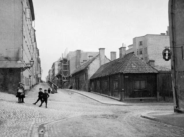 Några barn står i gathörnet där Brännkyrkagatan går österut från Timmermansgatan. Till höger Brännkyrkagatan 49-45 där cigarrfabriken Bergman &amp; Gösling, Brännkyrkagatan 45, är under om- och påbyggnad.