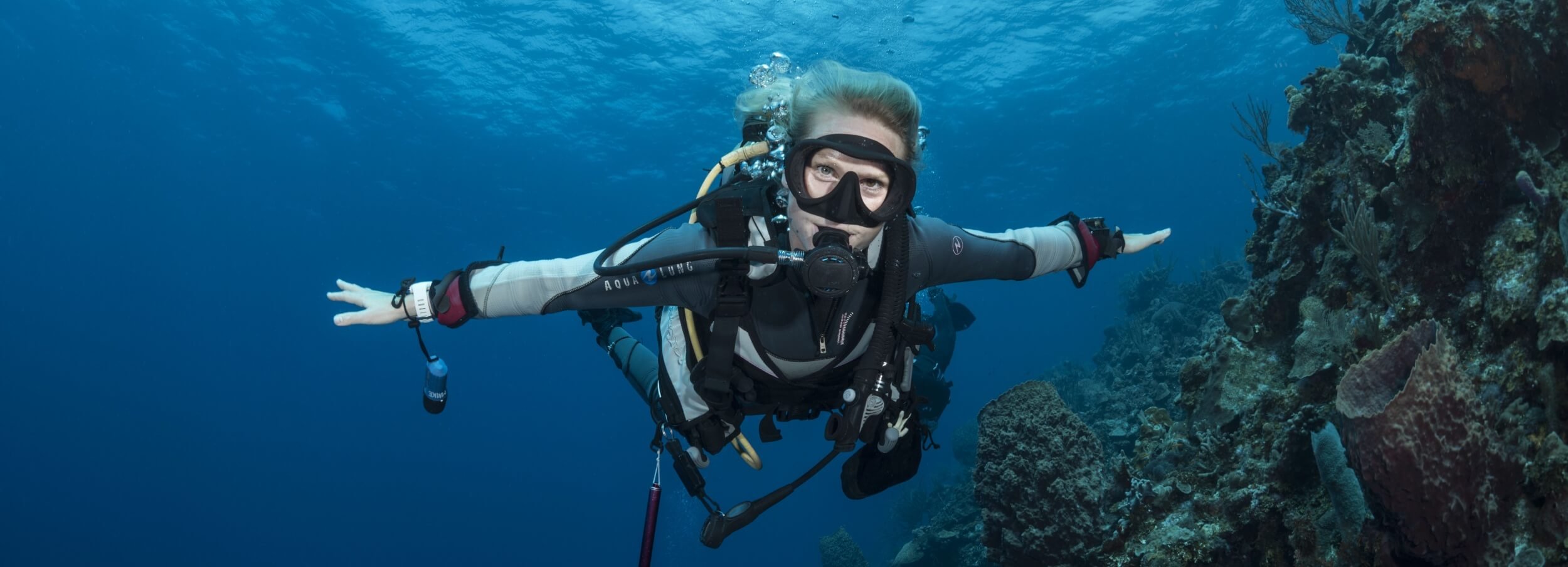 An instructor "flying" through Roatans crstal clear waters