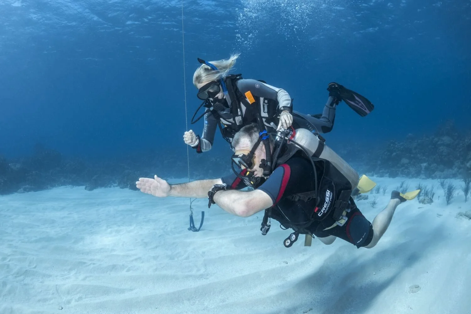 A PADI instructor helping a student learn navigation.