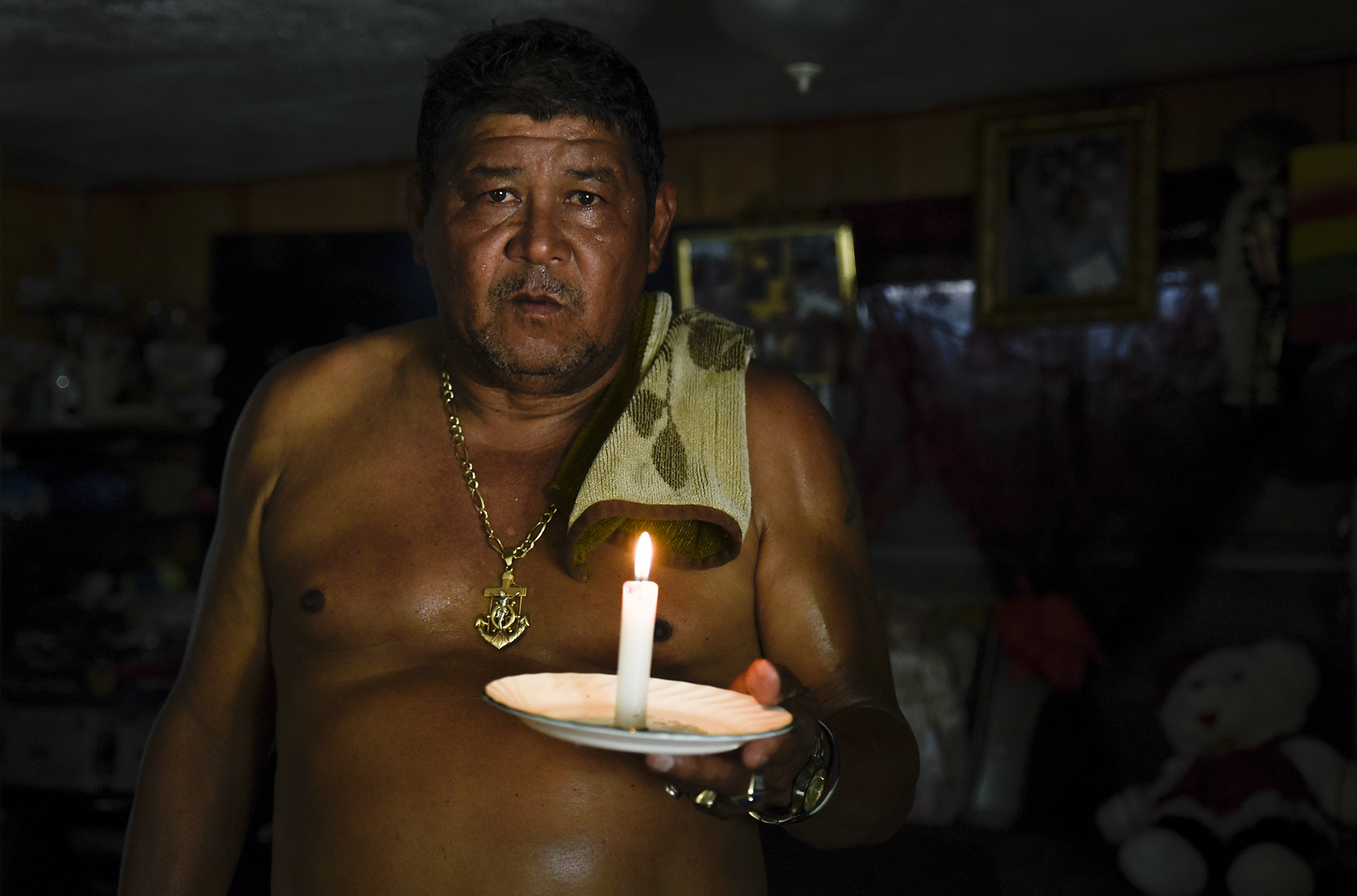  Fifty-nine-year-old Lake Worth resident Mario Velasquez stands for a portrait holding a candle, his main source of light at night, inside his Orange Grove Mobile Home Park residence in Lake Worth, FL. Velasquez said the neighborhood had been without