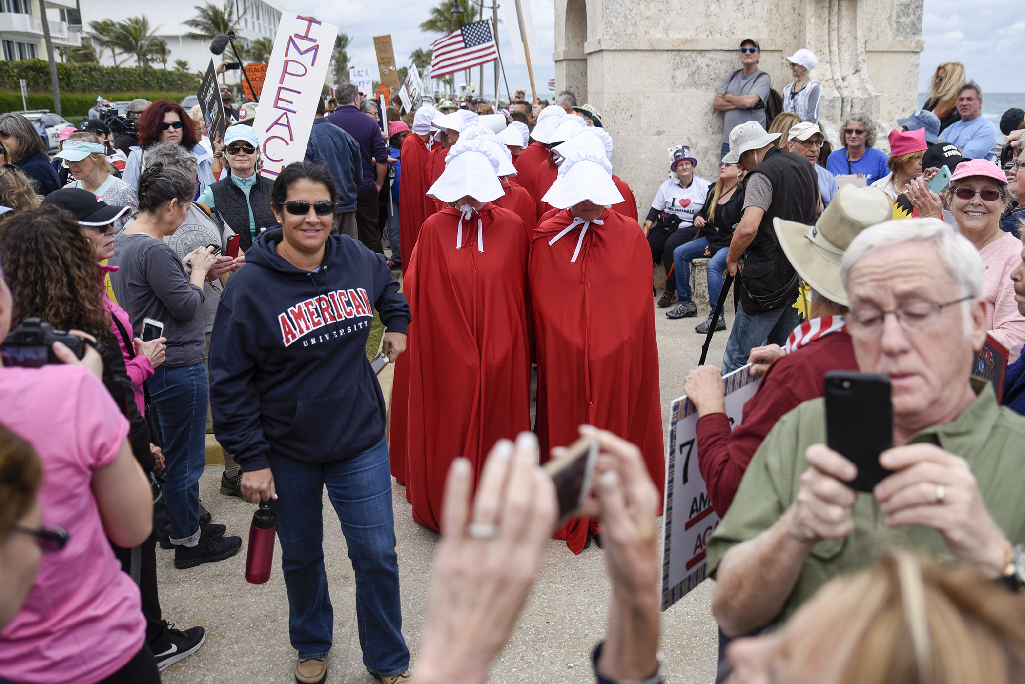  Protestors dressed as Handmaids from "The Handmaid's Tale" stand underneath the Clock Tower on South Ocean Boulevard before the start of the "Impeachment March to Mar-A-Largo" in Palm Beach, FL. Hundreds of participants gathered in Palm Beach to mar