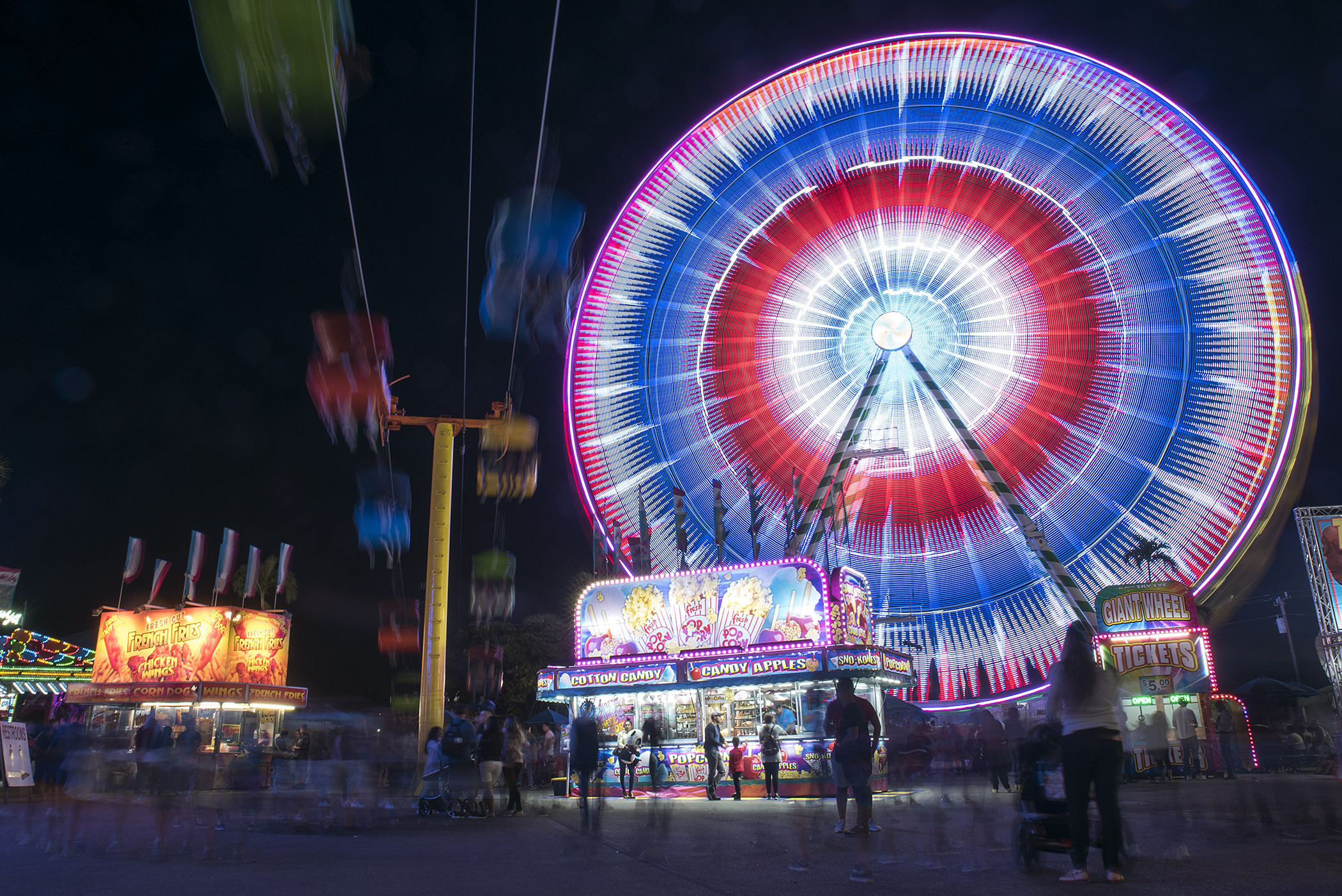  South Florida Fair guests are seen walking underneath the gondola and Ferris wheel rides after dark at the South Florida Fair in West Palm Beach, FL. Thousands of visitors come to the South Florida Fair to play games, eat food and see attractions du