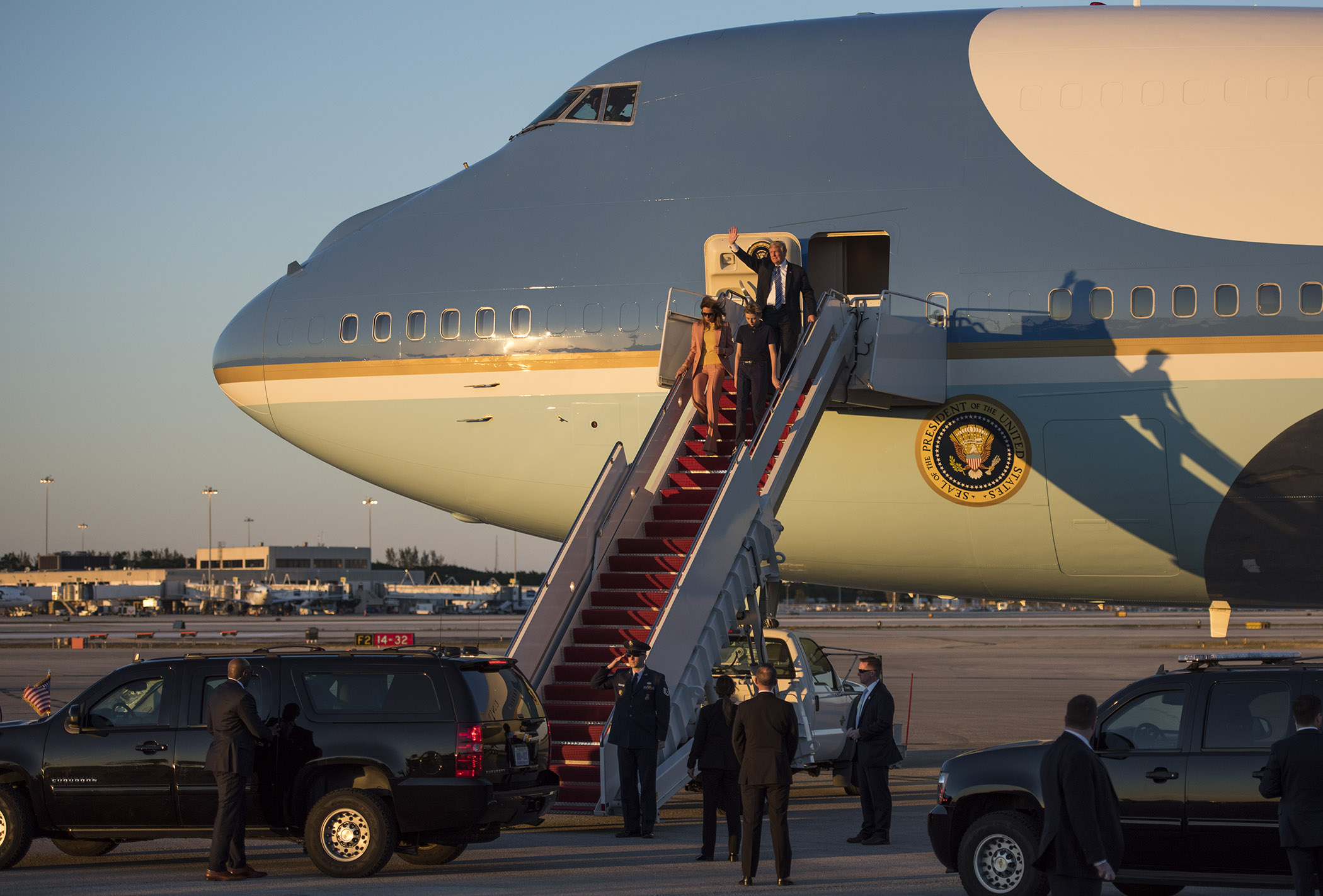  President Donald Trump waves to gathered supporters while descending Air Force One behind First Lady Melania Trump and their son, Barron Trump, during President Trump's arrival to Palm Beach International Airport in West Palm Beach, FL. 