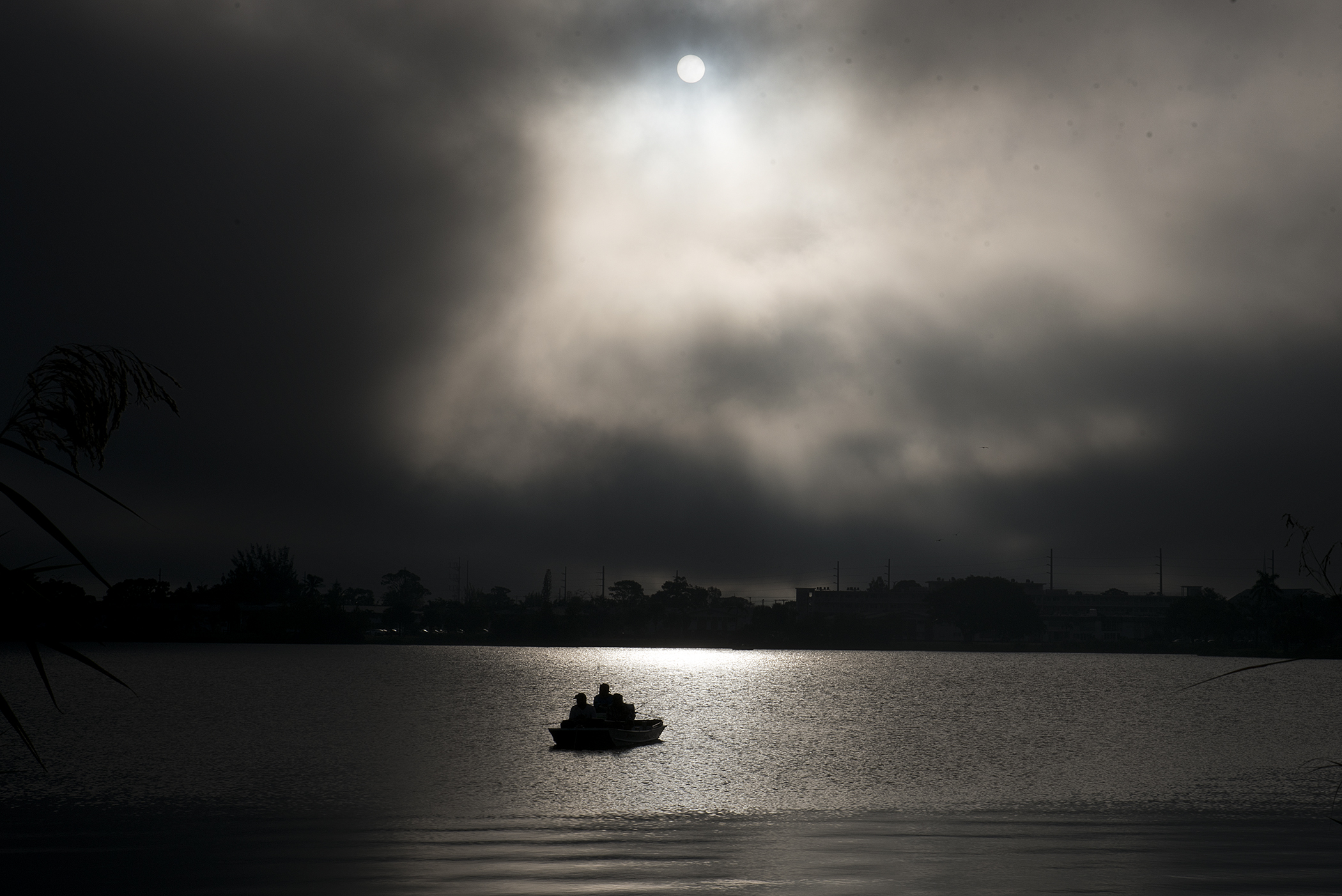  A trio of fisherman are seen in their boat on the Lake Osborne water early one cloudy morning in James Prince Park in Lake Worth, FL. 