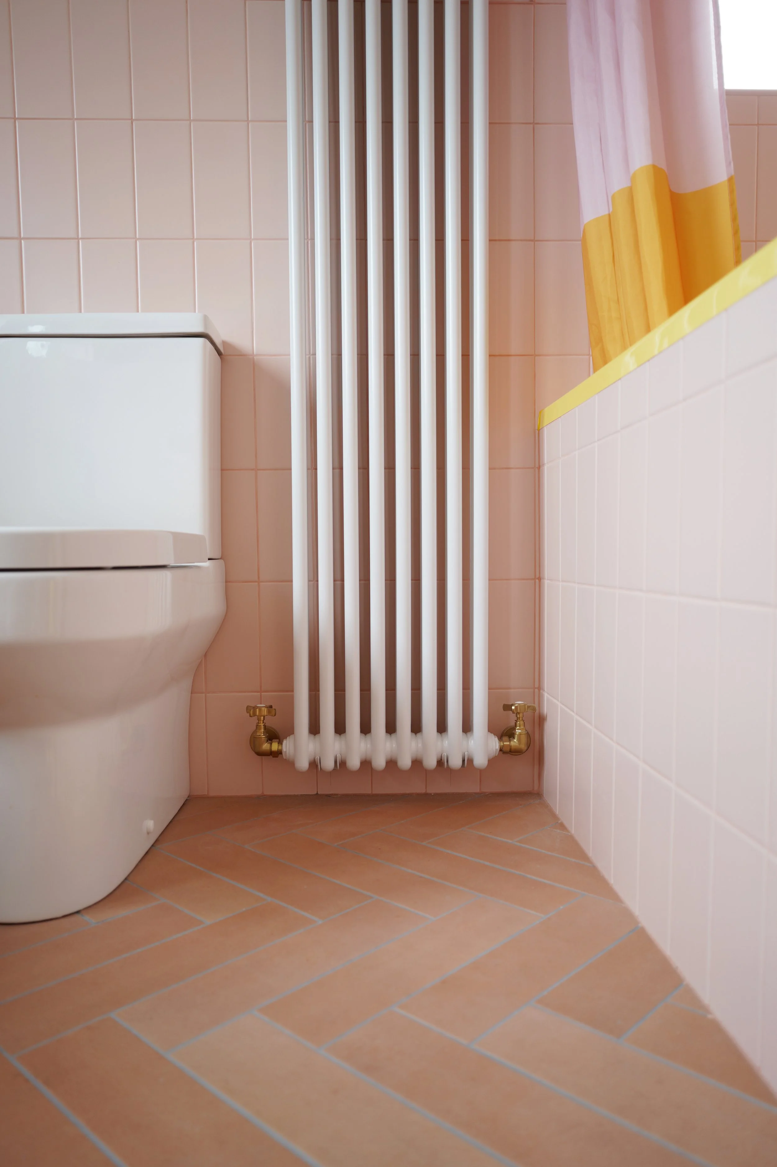 bathroom renovation Sheffield, pink bathroom, bathroom radiator, terracotta tile floor in herringbone