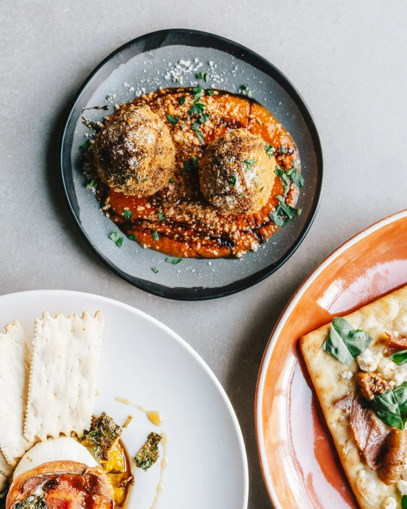 top down of arancini, burrata with crackers, and fig and goat cheese pizza (Copy)