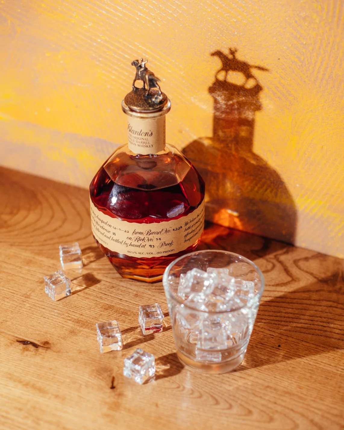 bottle of Blanton's bourbon with ice cubes and a whiskey glass (Copy)