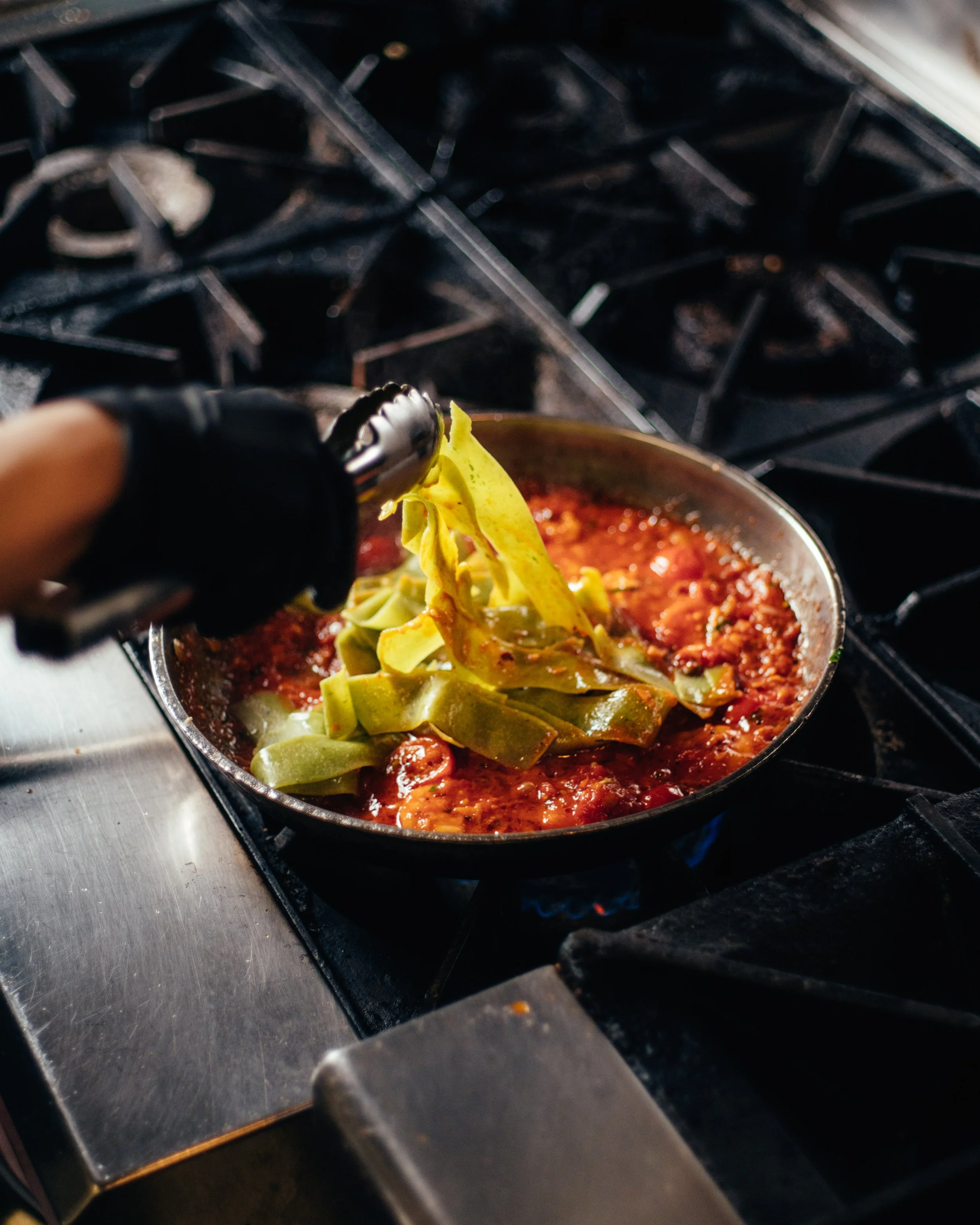 adding mafalda pasta to shrimp pappardelle on stove top (Copy)