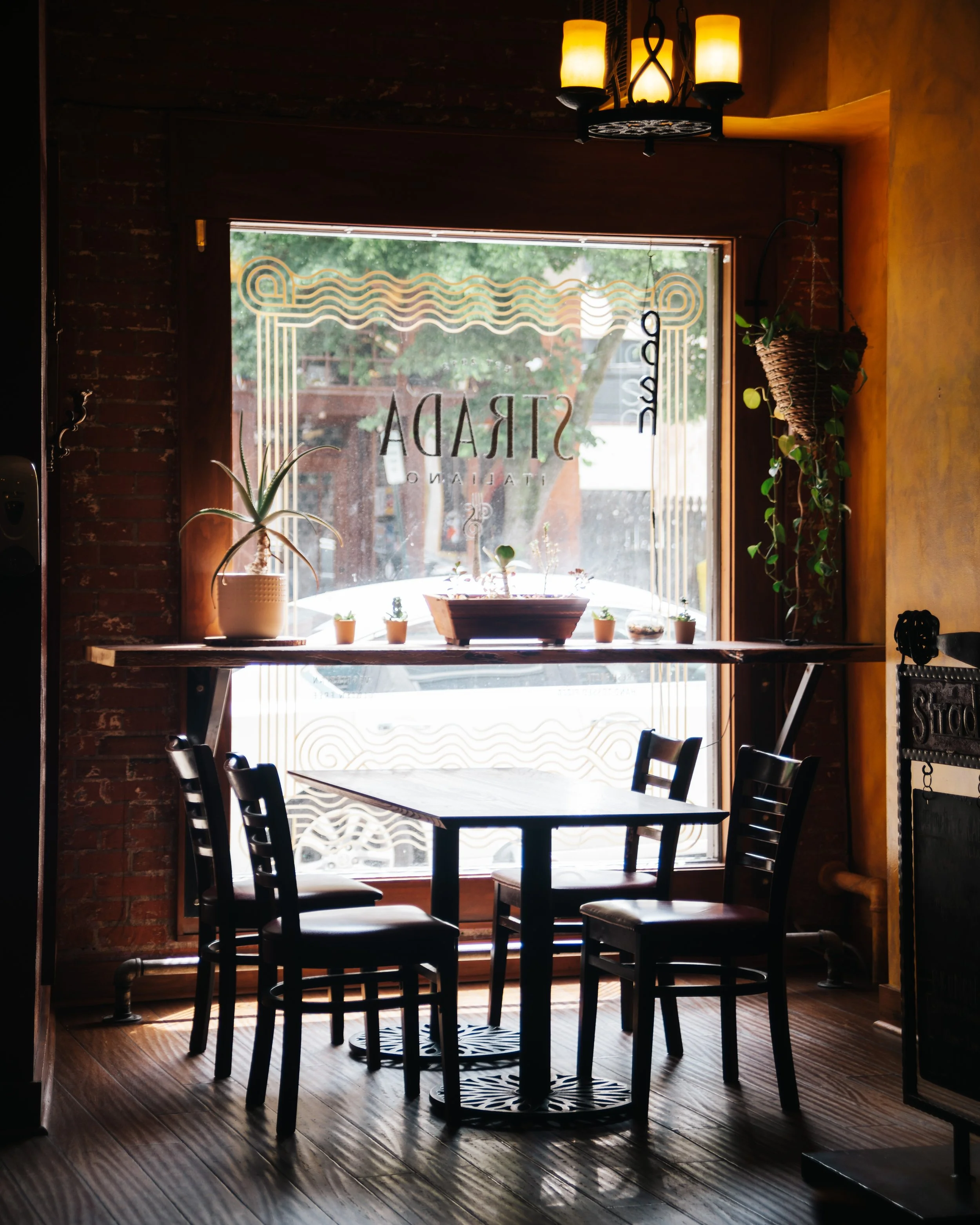 table and chairs by big bright window in Italian restaurant in downtown Asheville (Copy)
