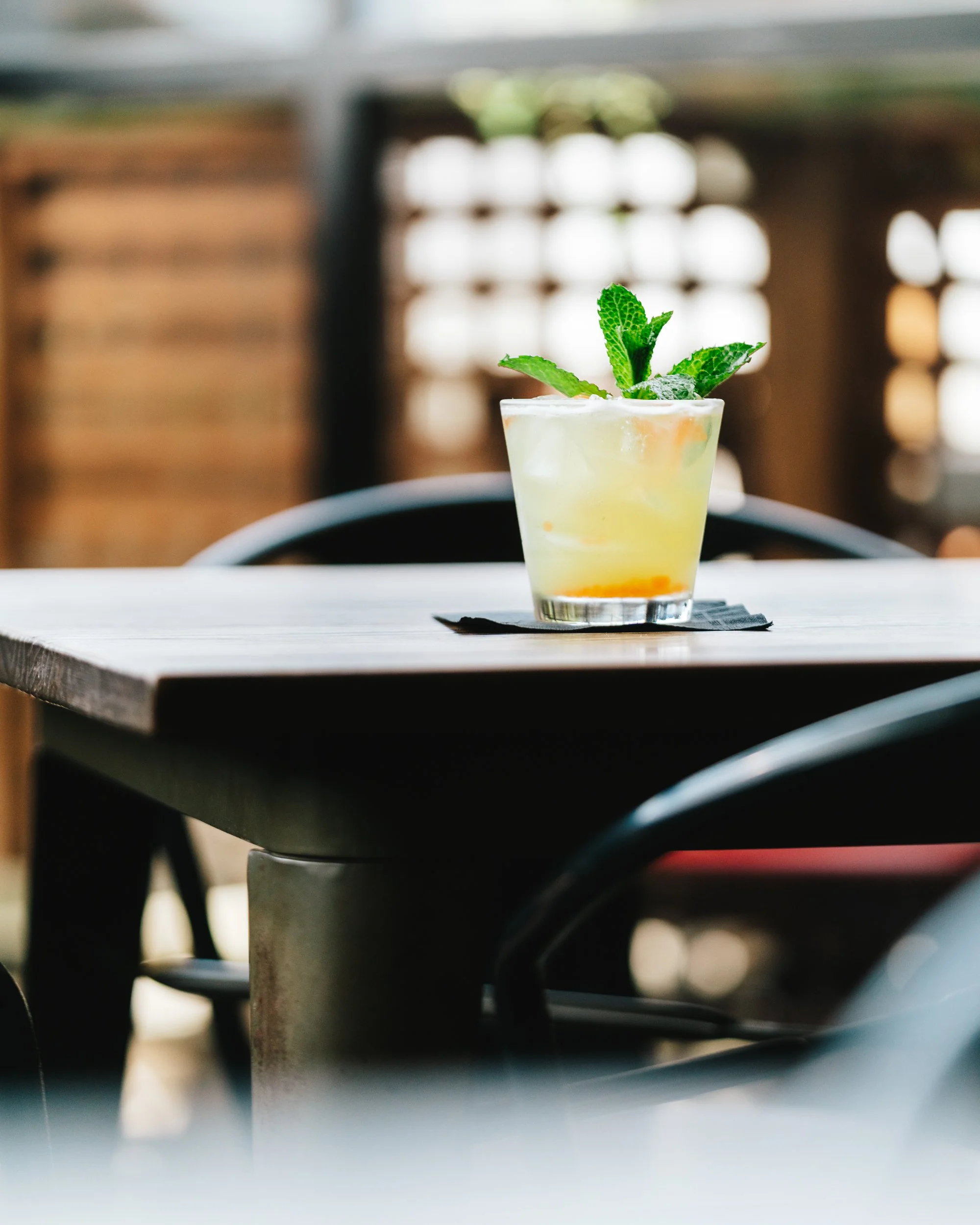 yellow cocktail with fresh mint on rooftop patio table