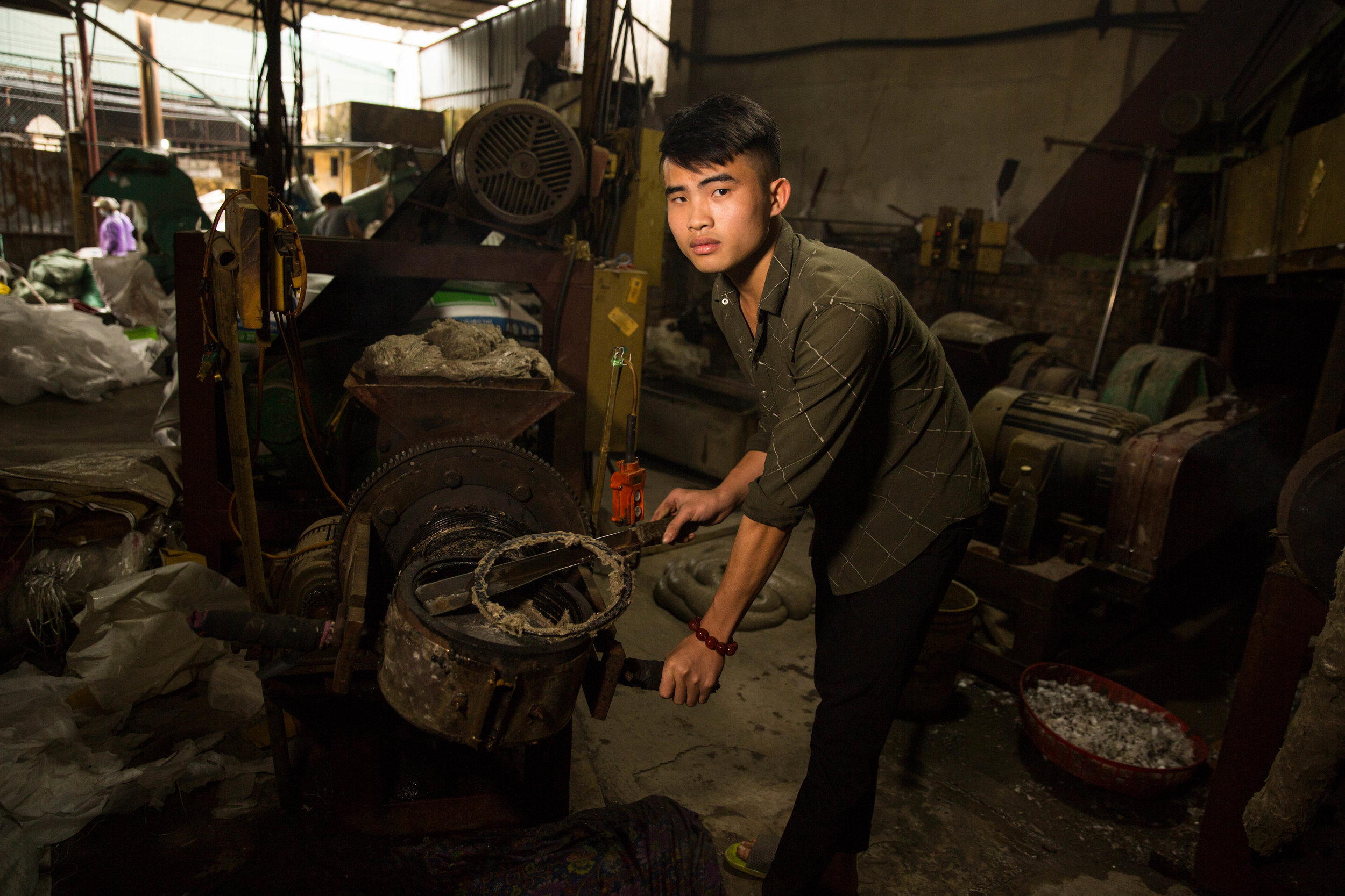 Lo Van Dinh, 21, operates a machine to melt plastics in Minh Khai, Vietnam, on Thursday, Jan. 17, 2019. The village is a hub for recycling both domestic and foreign plastics.