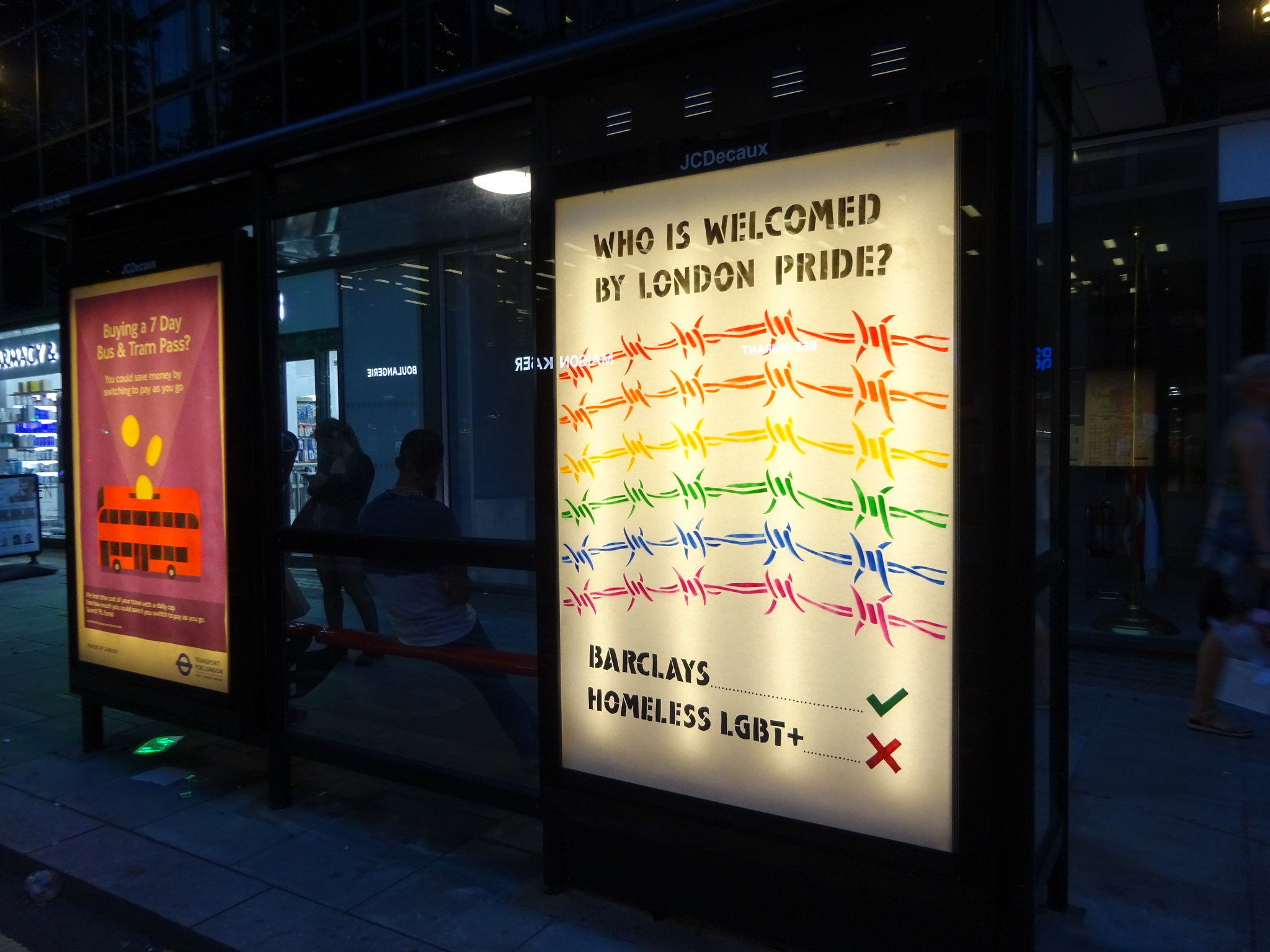 Bus stop adhack by Lesbians and Gays Support the Migrants and Protest Stencil protesting the exclusion of LGBT+ asylum seekers, homeless people and community groups from Pride in London