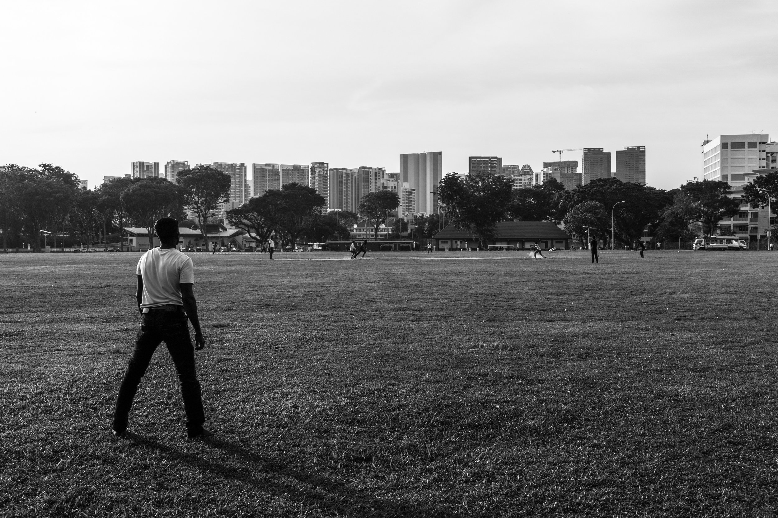   Sporting at heart . Migrant workers pitch themselves against one another over a game of cricket. Cricket is a national sport back in their home country. 