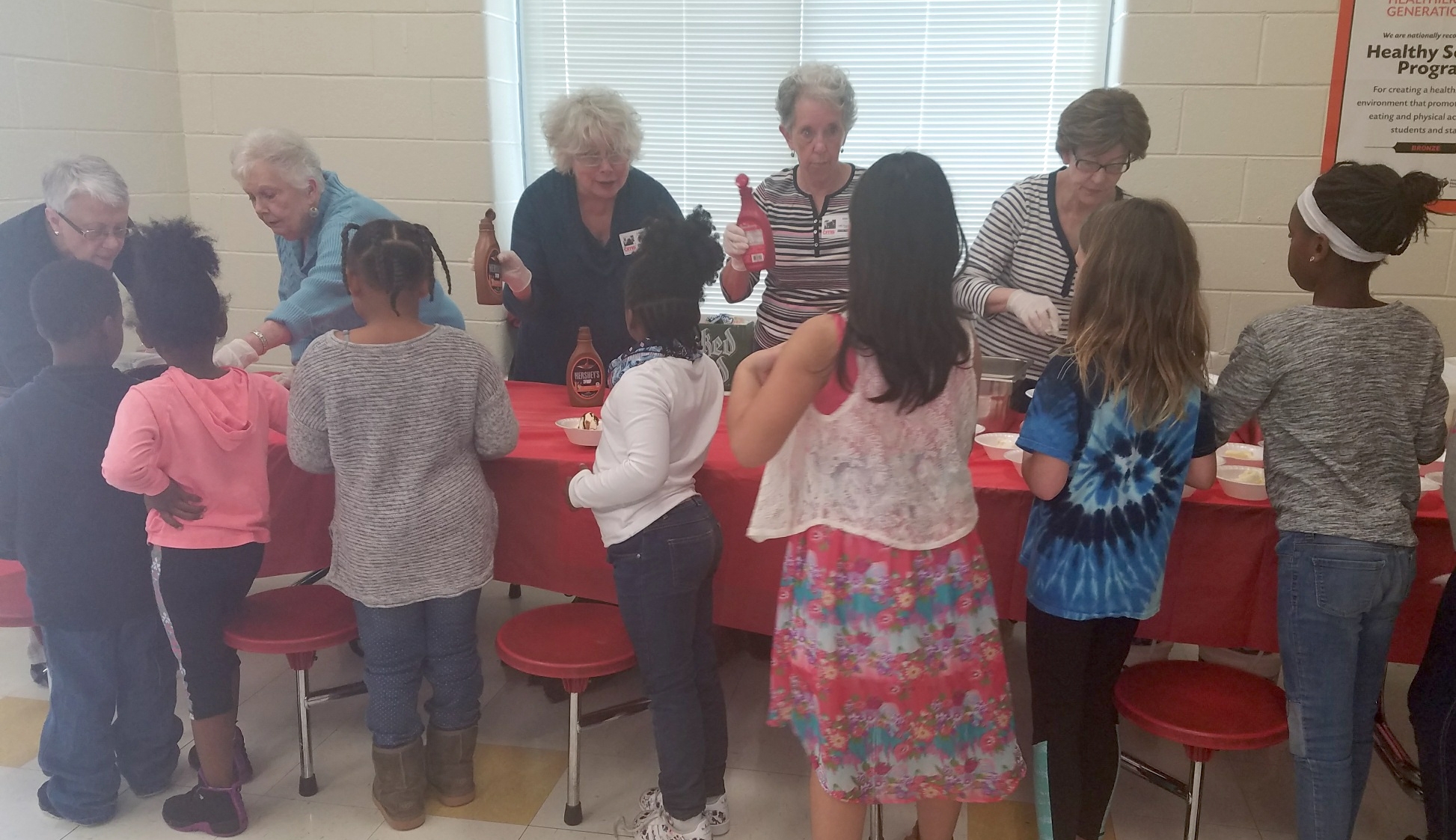   At quarterly ice cream parties, church members serve ice cream to students from First Ward Creative Arts Academy to celebrate their achievements.  