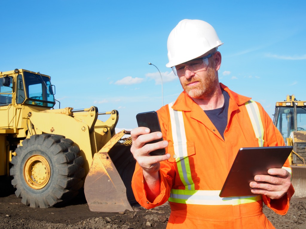 construction-worker-and-computer-and-phone-technology-picture-id532113455.jpg