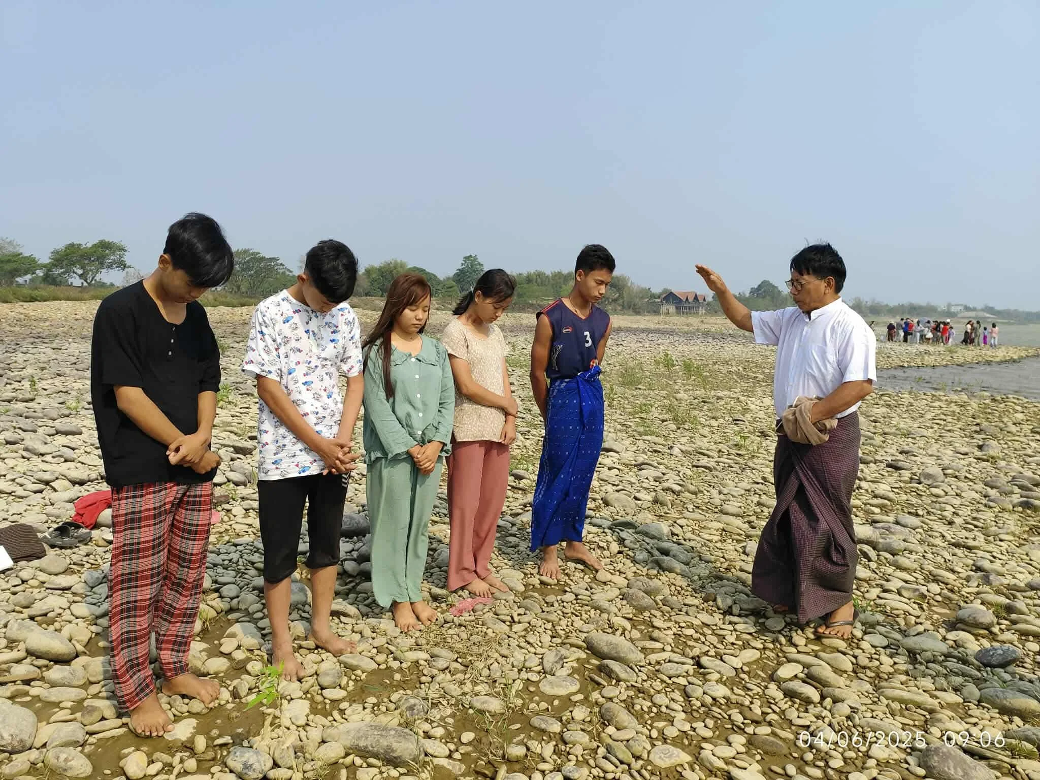 Uzziah praying over new believers before their baptism