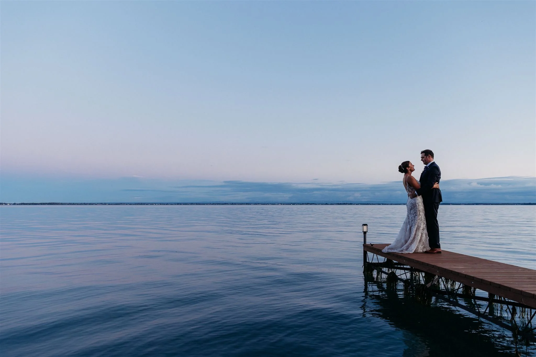 Montreal married couple poses on a pier on Lake St. Francis in Saint Zotique