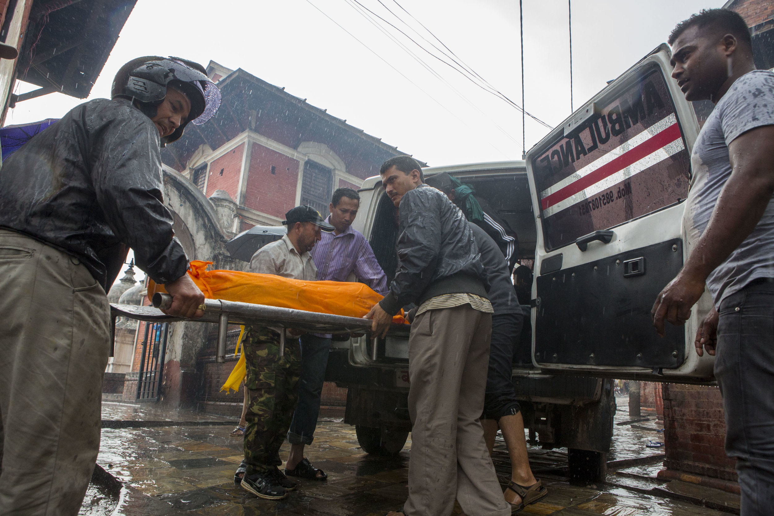  Men unload a body from an ambulance at Pashupati in order to begin its cleansing on the river bank.&nbsp; 