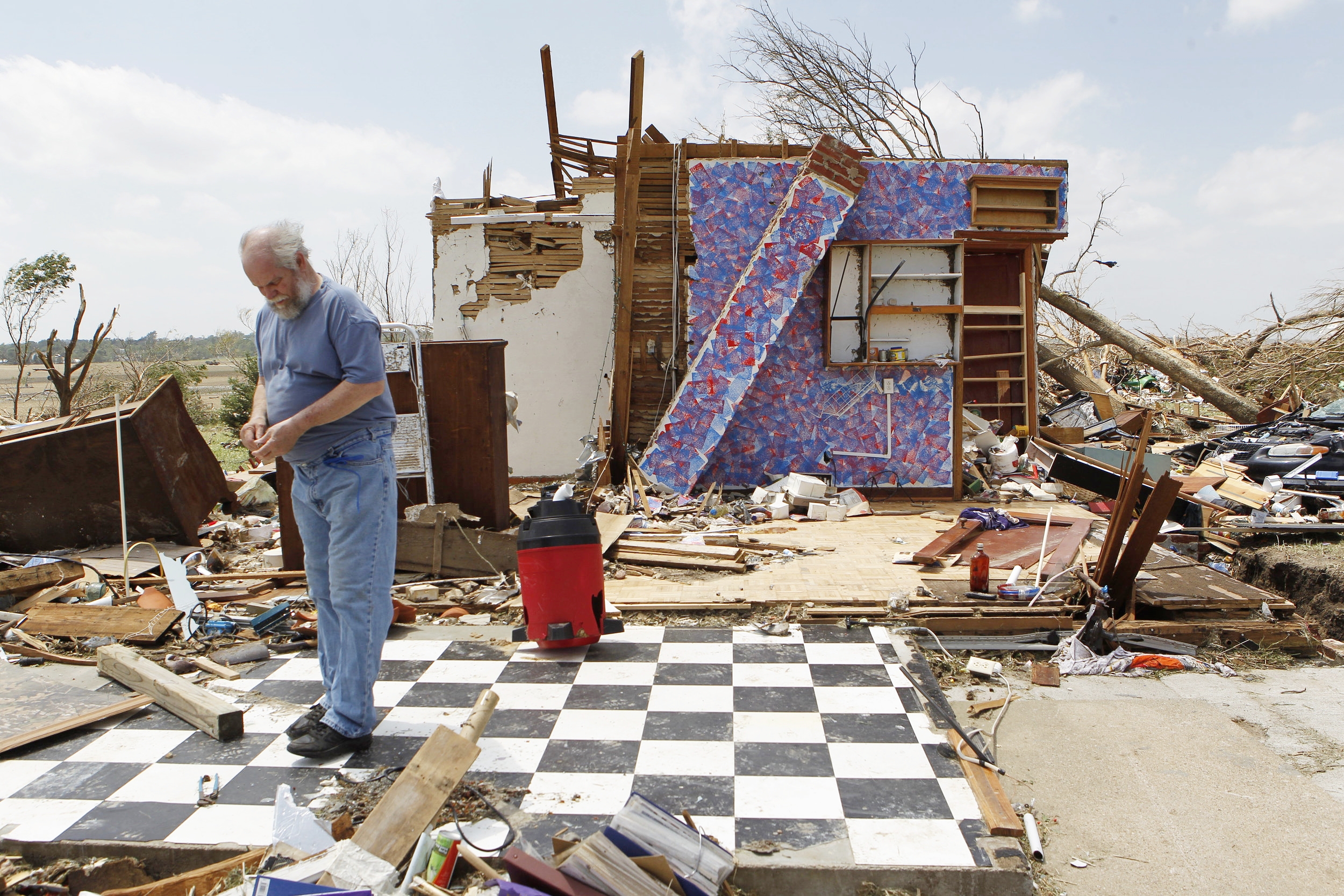  Greg Dunn looks through his scattered belongings on June 18, 2014, after his house was hit by a tornado near Coleridge, Neb. Within the same week Dunn lost his home to an EF3 tornado and lost his wife of 38 years, Diane, to a heart attack. 