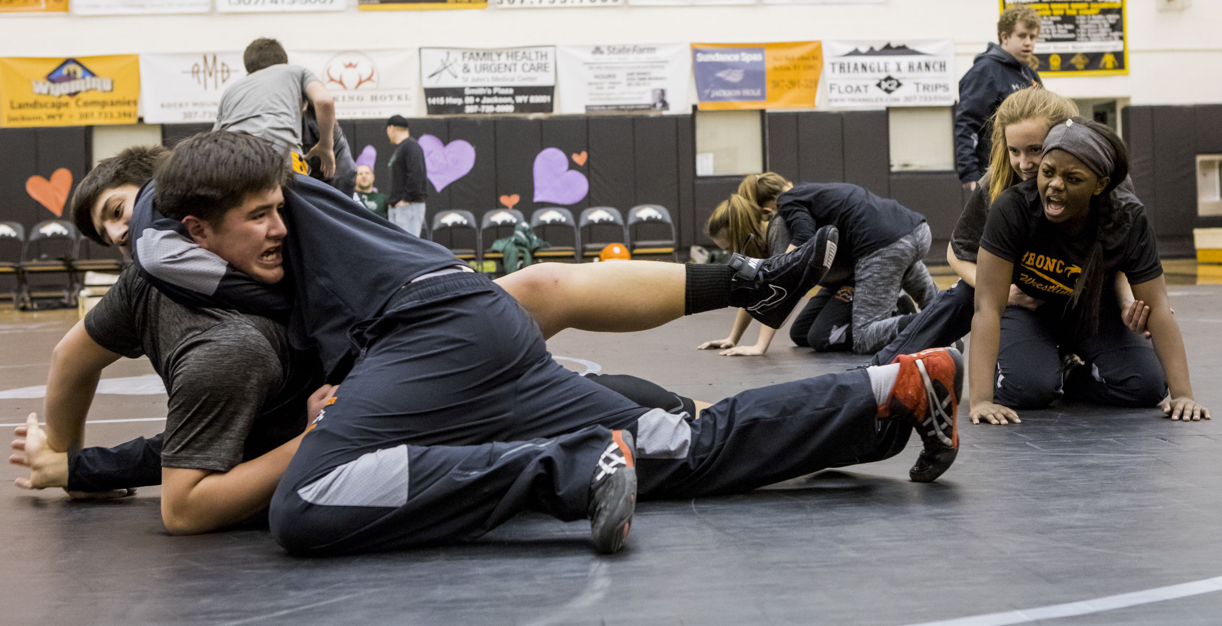  (right to left) Annie Batchen and Elizabeth Jensen encourage their teammates Joseph Romero and Jack Brown during warmups before their meet against Green River at Jackson Hole High School on Feb. 9, 2018. 