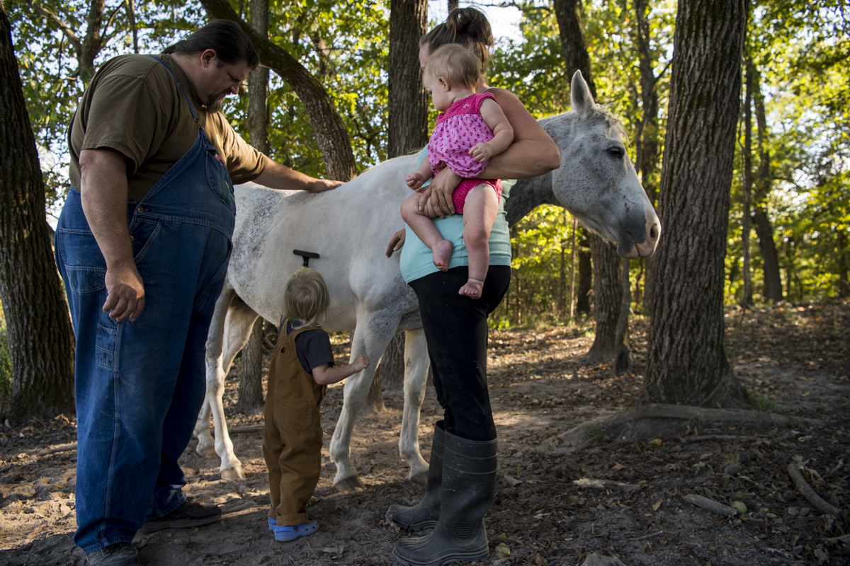  Carl Blake, Jakson, 2, girlfriend Courtney See and nine-month-old Presley care for their horse Shiloh in a pasture on their Eldon, Mo. farm. The family does most chores together so that the children learn about the famer’s way of life. 