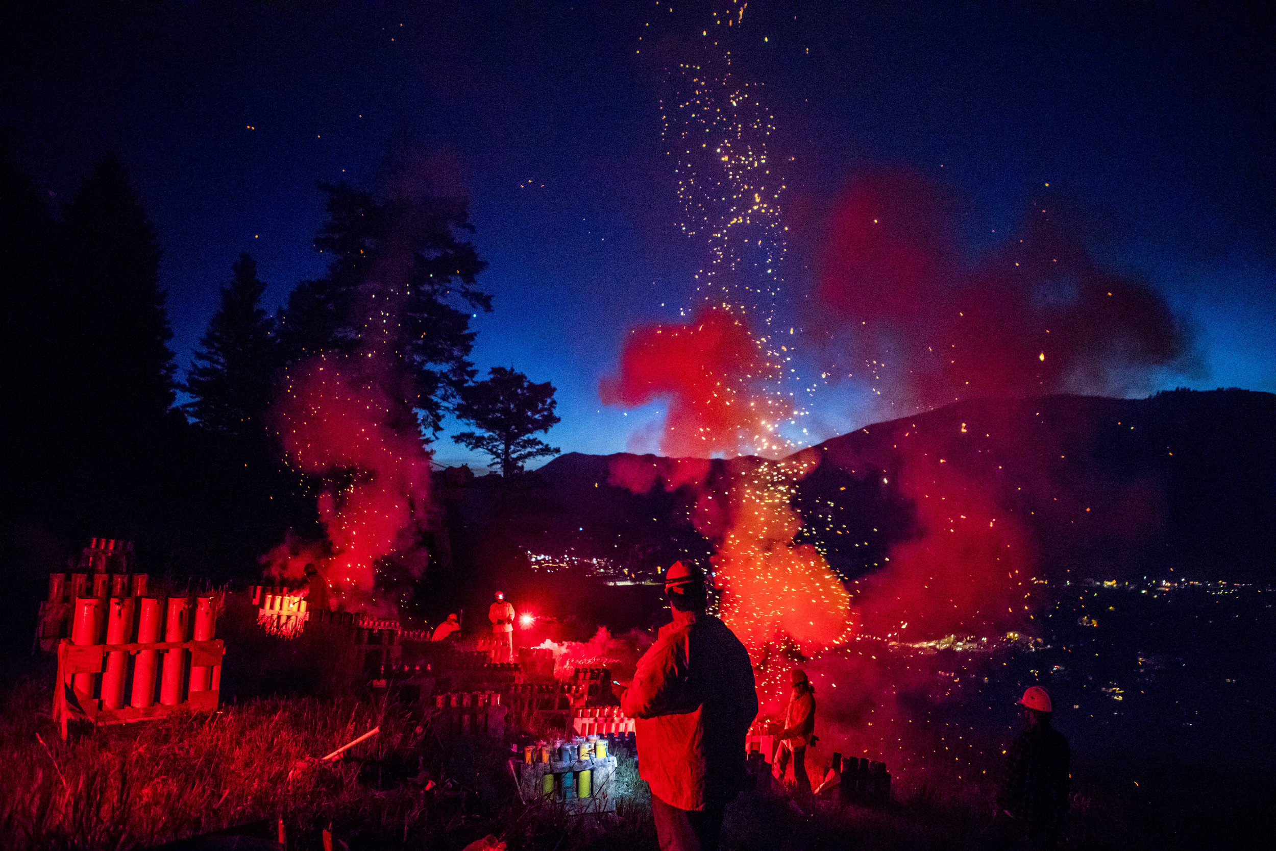  Bob Hammond conducts volunteers as they light off the Fourth of July fireworks display from Snow King Mountain in Jackson, Wyo. Hammond has led the display for over 20 years. 