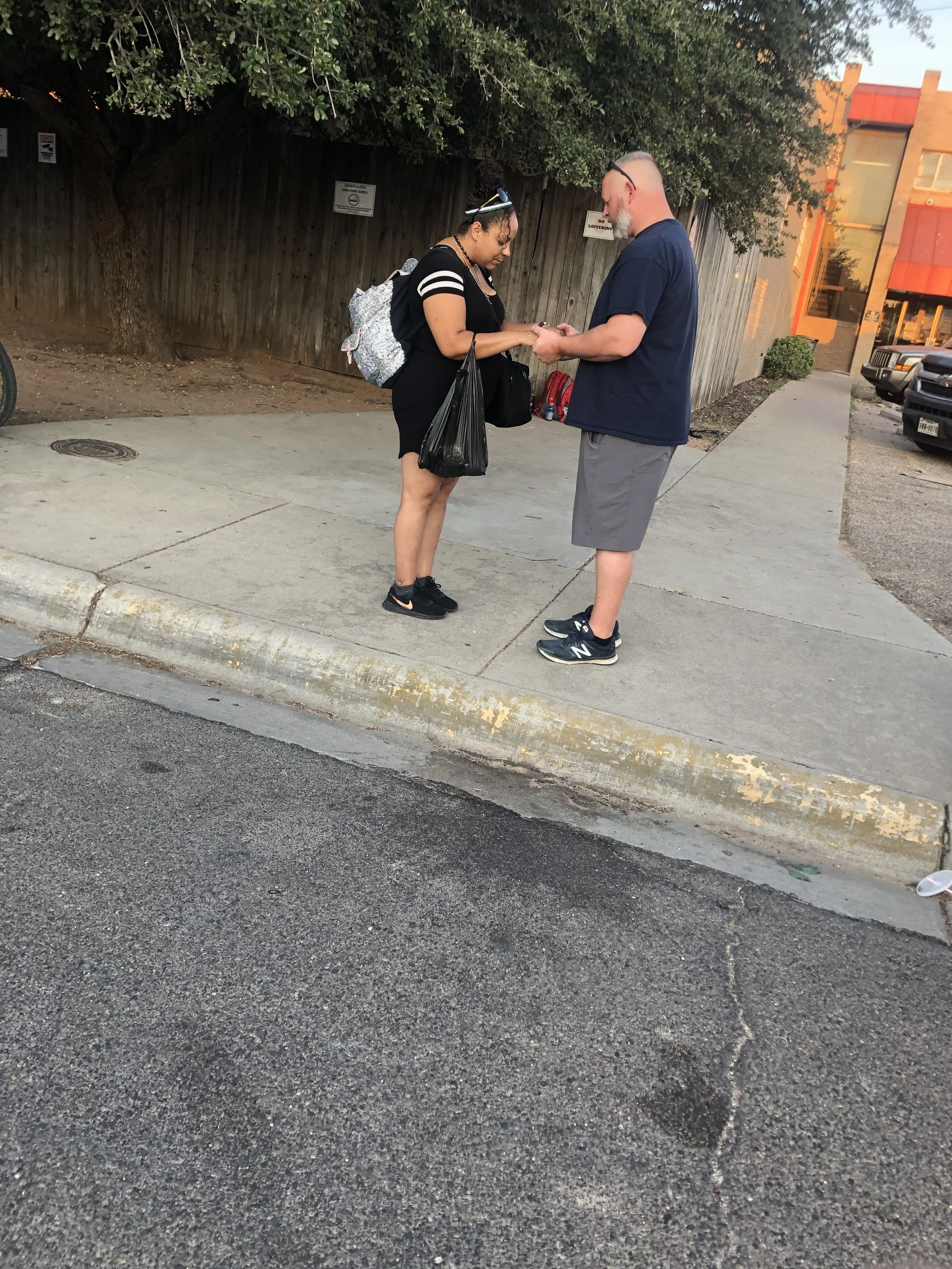 Breaking Bread Mobile Ministry Director praying with woman outside of the shelter