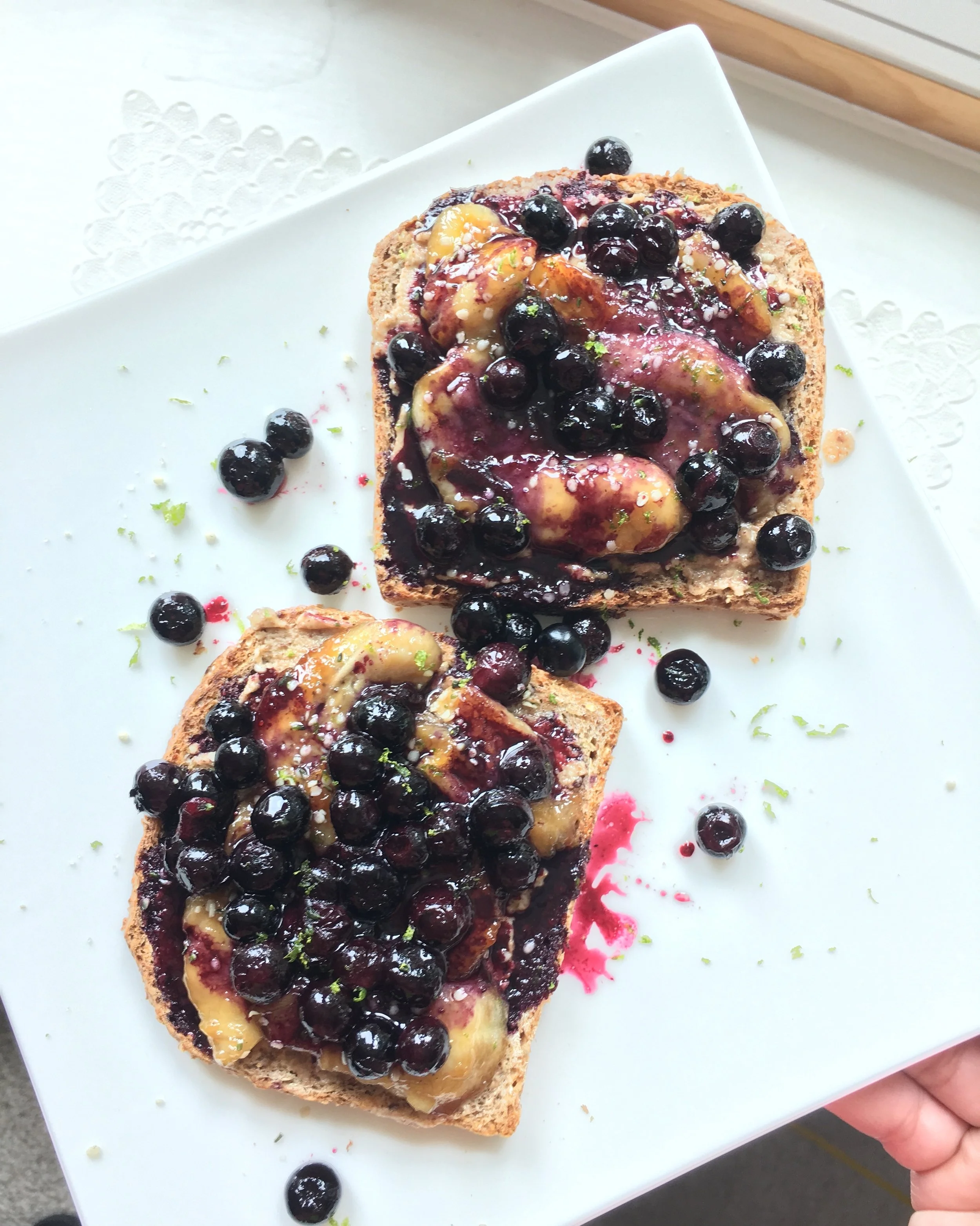 Homemade breakfast toast: Ezekiel Bread with homemade almond butter, topped with pan fried banana and caramelized blueberries!