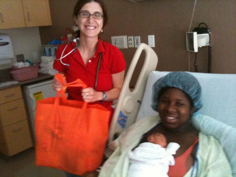 A homeless mother holding her newborn in the hospital receives a Circle of Hope Welcome Baby Bag.
