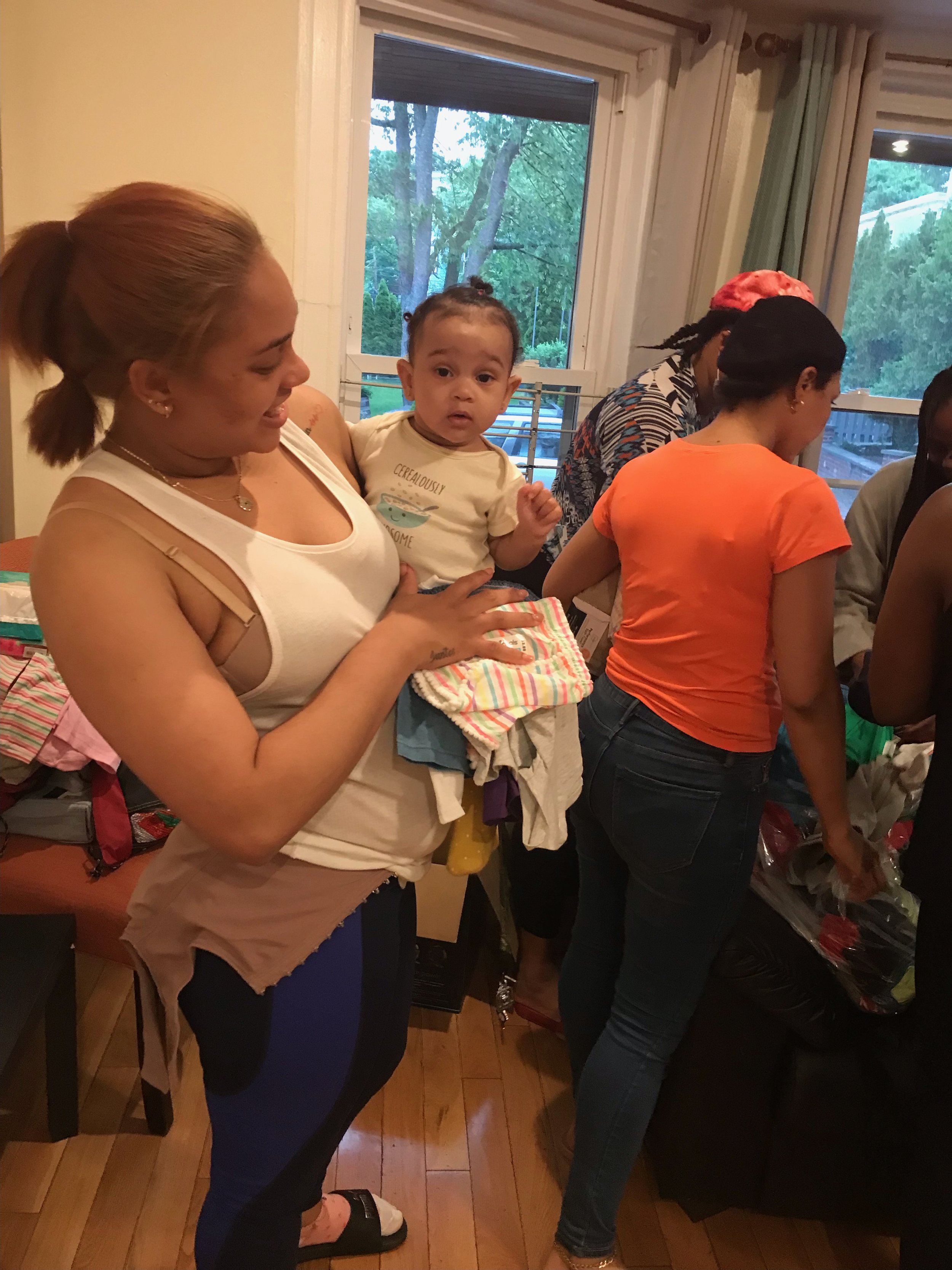  In the common area of a Boston family shelter, families opened bags of Circle of Hope donations together. Each parent selected the items they needed for themselves and their children this summer. 