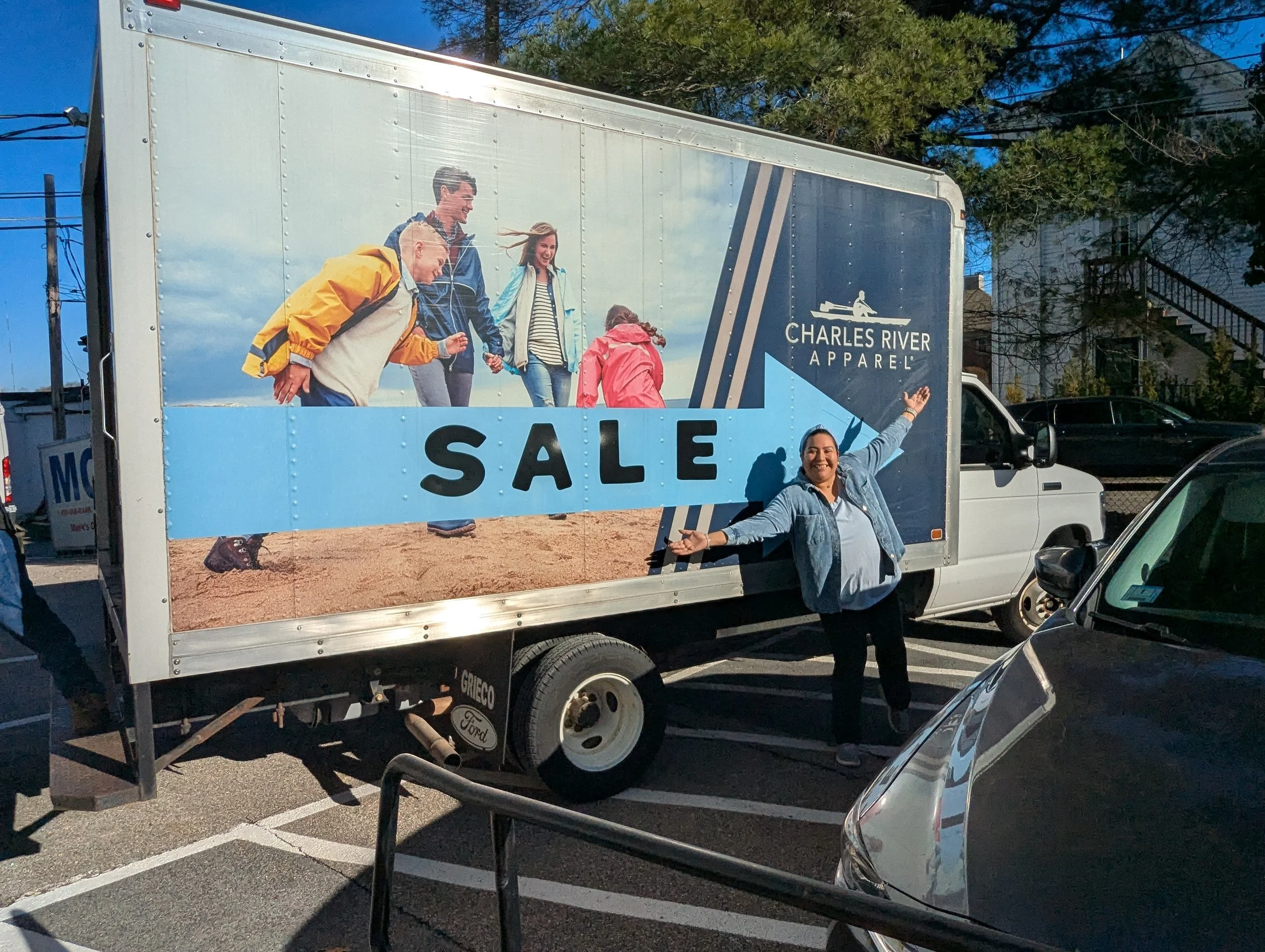 Victoria Connors, Circle of Hope's Office Manager, poses in front of the Charles River Apparel van.