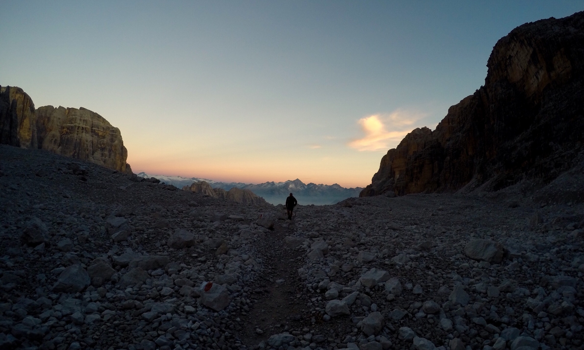 Young man walks off into the distance in the Brenta Dolomites at sunset