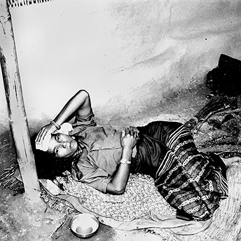  An ill woman lies outside her hut.&nbsp; Many people get sick in the summer season because it is so hot in the camps.&nbsp; Bishnu Maya  / PhotoVoice / LWF  