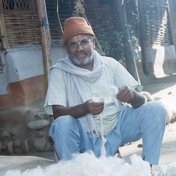   An old man works with wool to earn some money.&nbsp; He hopes that he will be able to return to Bhutan.&nbsp; Indra / PhotoVoice / LWF  