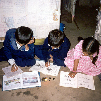   These students are trying to do their homework in their huts by the light of a small small flame. Students are compelled to finish their homework and study in the daytime because we are not provided with fuel for lighting.&nbsp;&nbsp; Bhakta / Phot