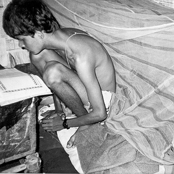 He is my brother. He is studying in Class VIII. He wakes up early in the morning because his examinations are very near. He is naked, sitting on the bed, because he has just woken up, lit the lantern and started studying. Yamuna / PhotoVoice / LWF