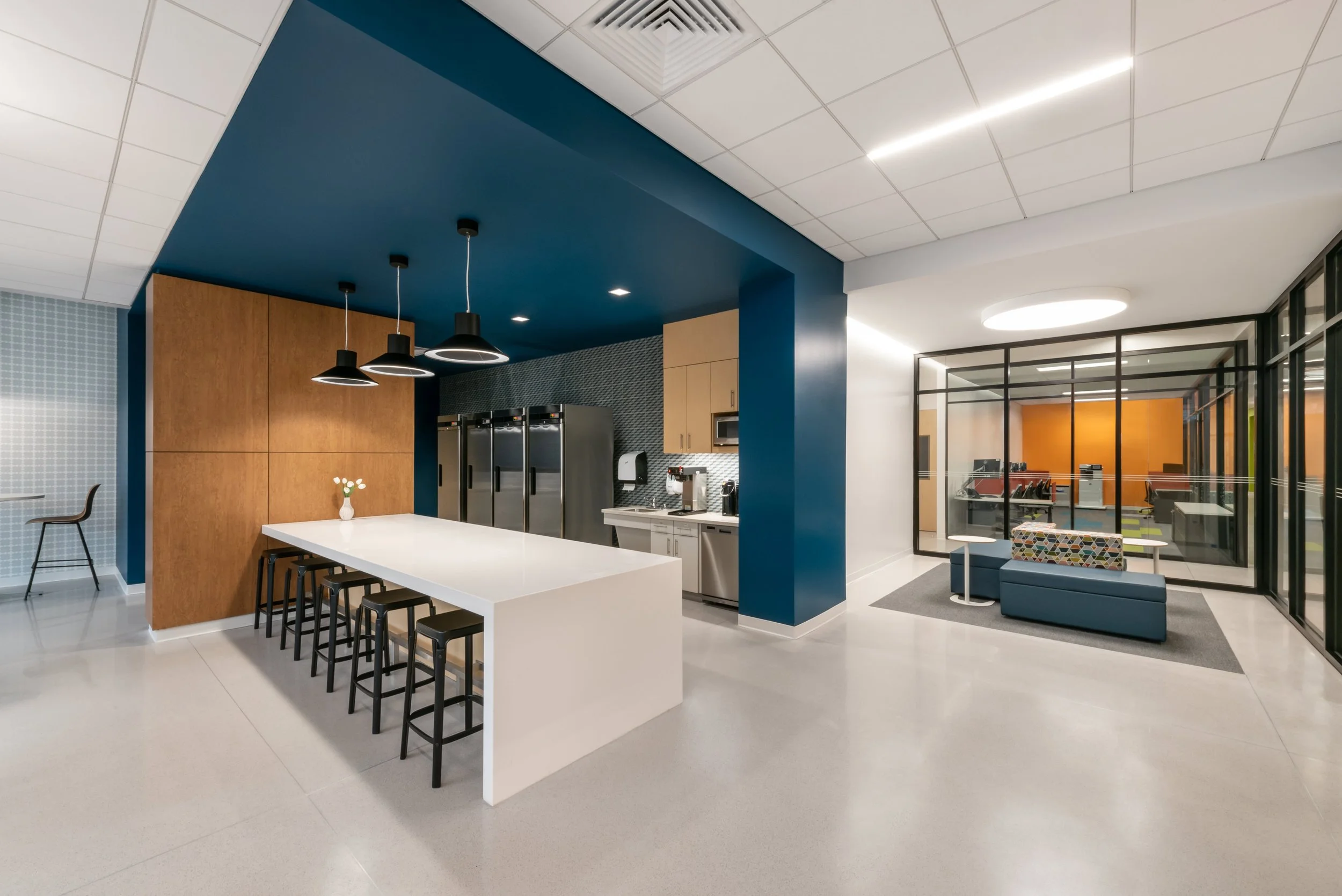 Polished concrete flooring in Regional Clinical Laboratory break room with modern seating and blue accent wall