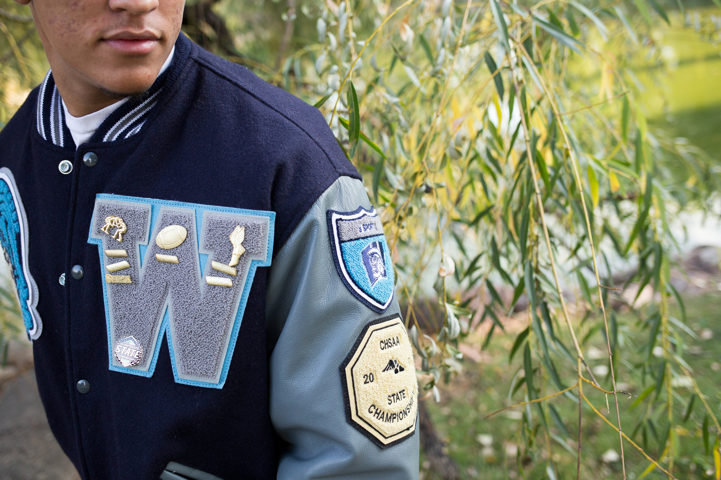 Widefield High School senior photos of varsity jacket close up at Monument Valley Park in Colorado  Springs Stacy Carosa Photography