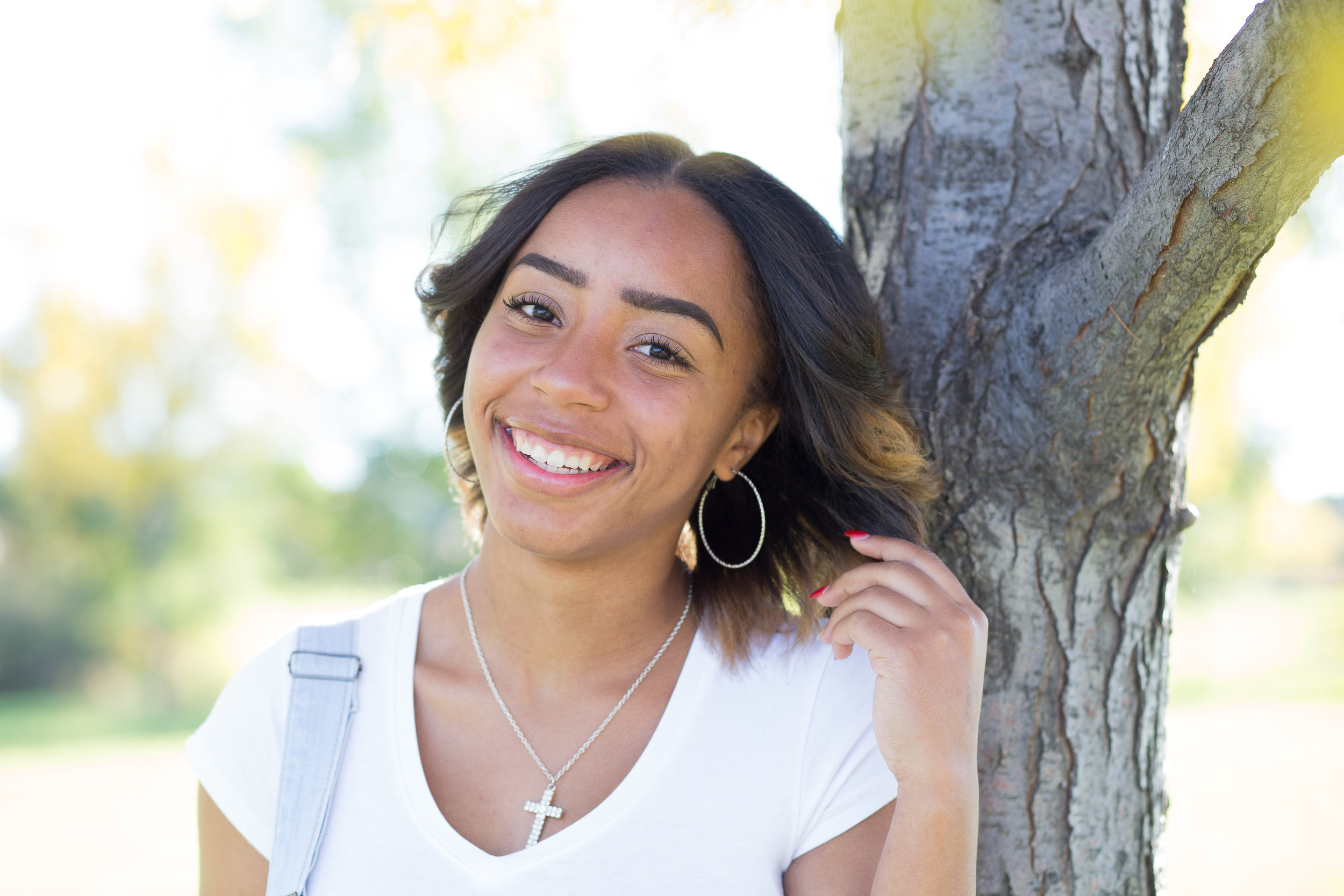 Senior photo session at Fountain Creek Regional Park in Colorado Springs senior girl holding hair and smiling and laughing at camera Stacy Carosa Photography Widefield High School