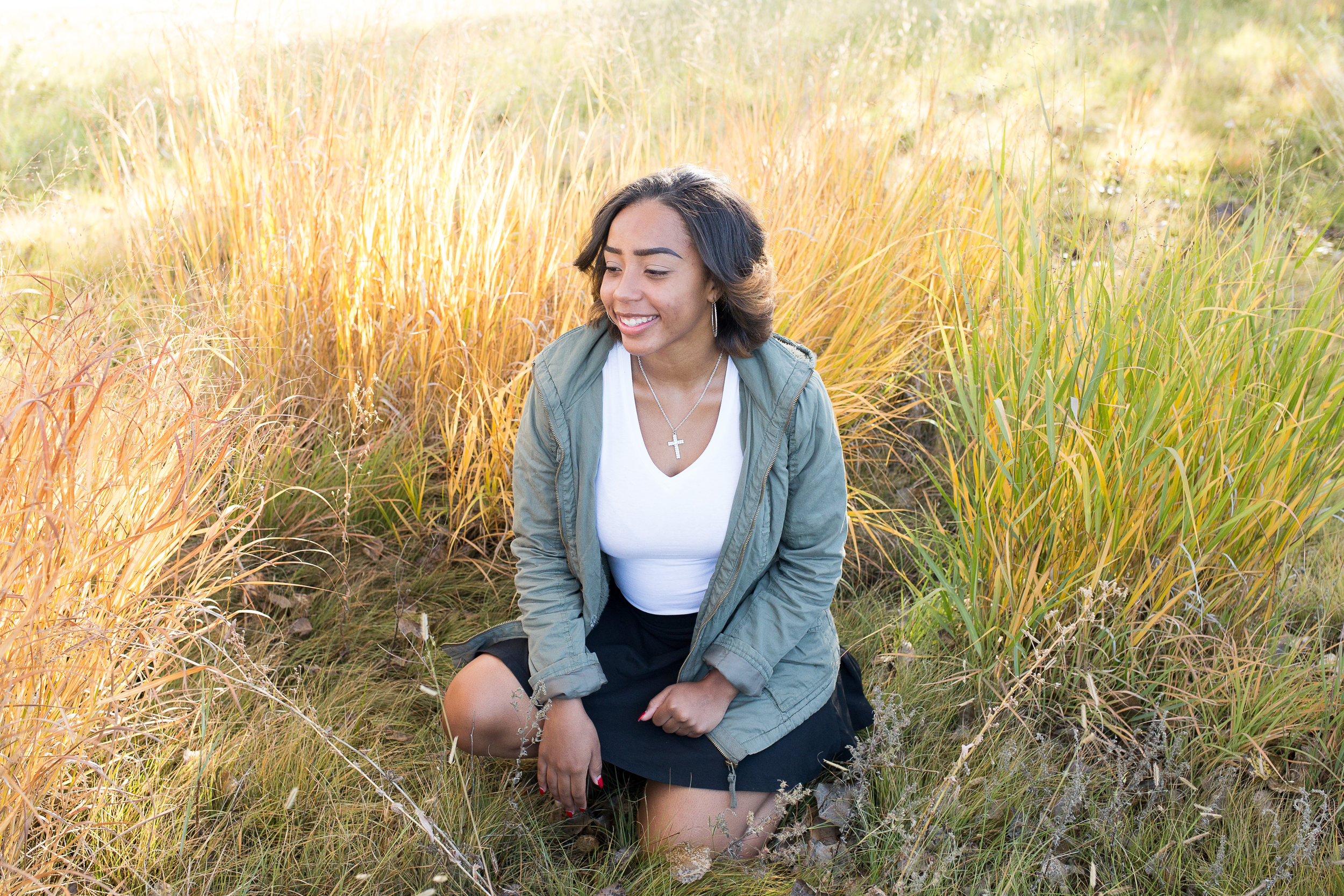 Sitting among the colorful tall grasses in Fountain Creek Regional Park for senior pictures Stacy Carosa Photography Colorado Springs Denver Senior Photographer